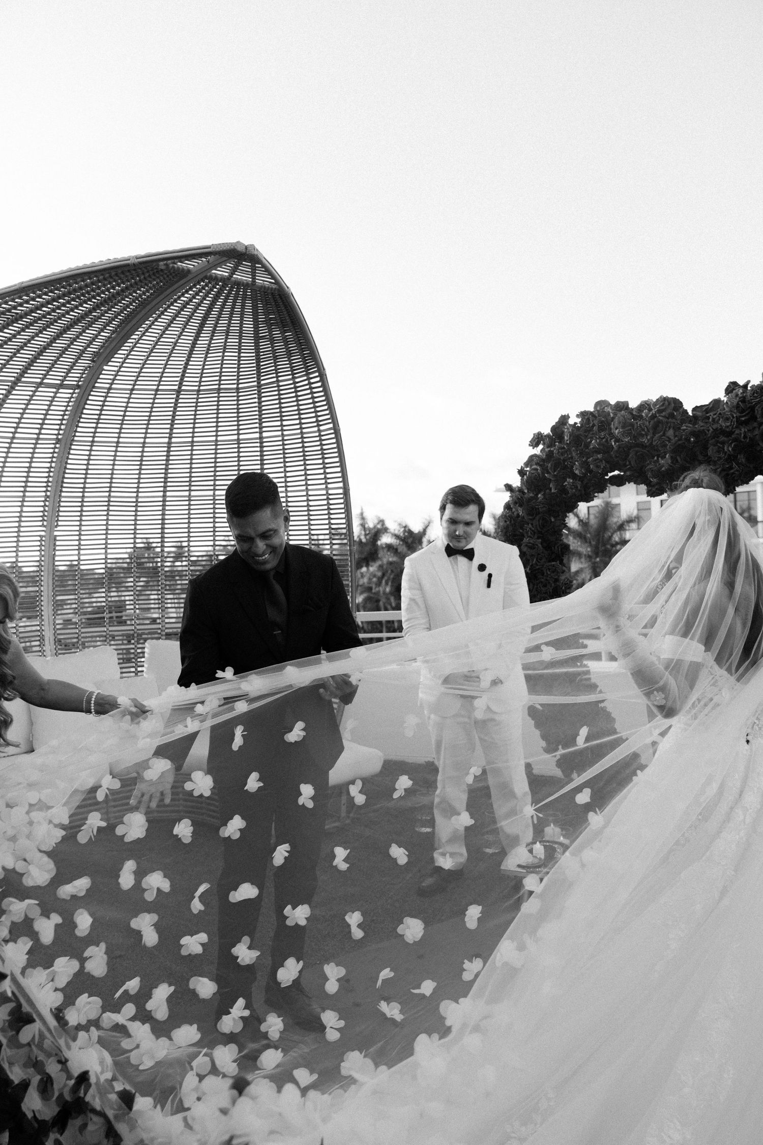 Four wide-angle monochrome photos show a fluttering bridal veil against a domed architectural background.