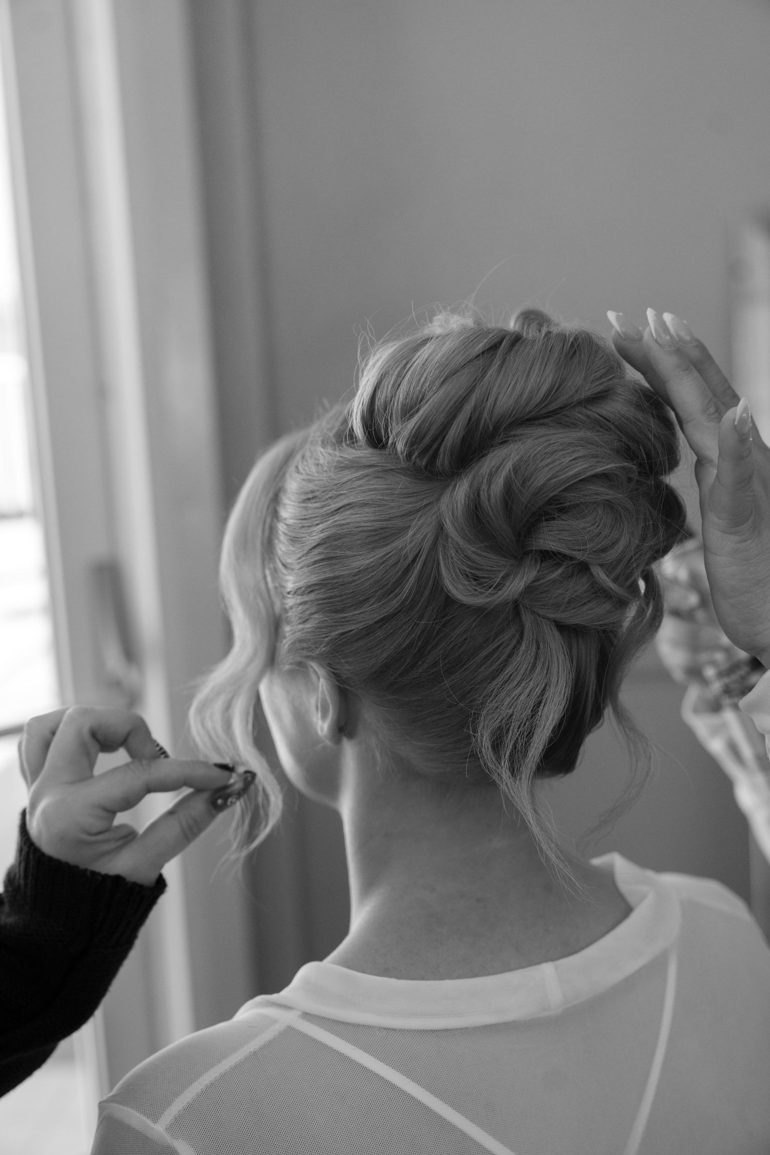 Series of black and white photos showing wedding hairstyling process from behind.
