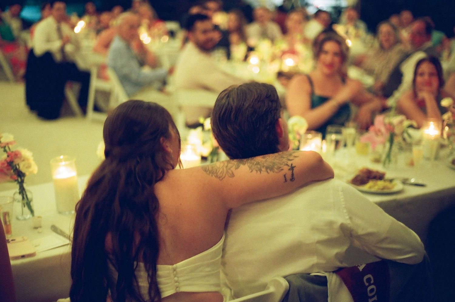 An image of a couple, likely at a wedding reception, embracing and dancing together on a dance floor.