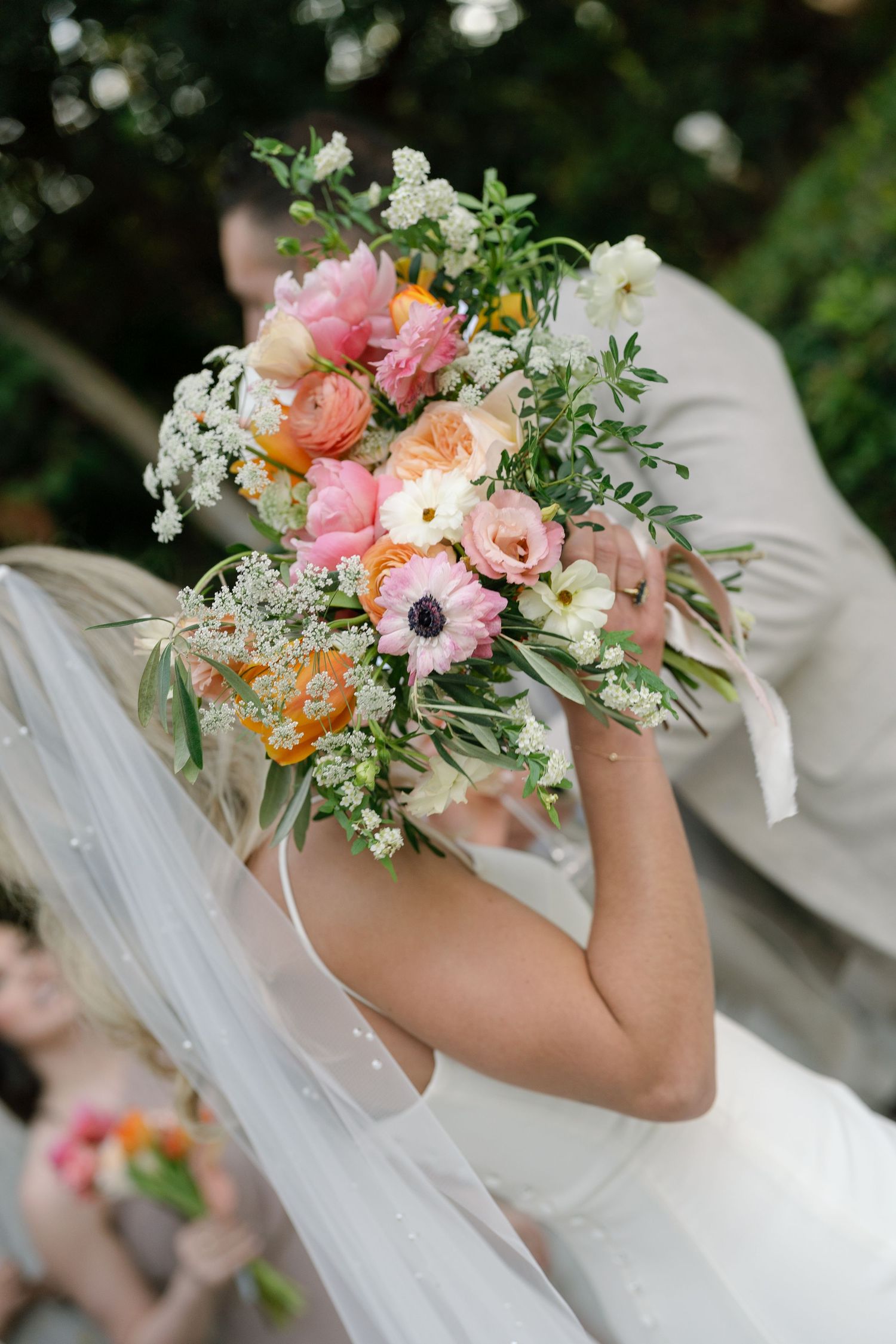 A row of elegant wedding bouquets featuring pink, peach and white flowers with delicate greenery.