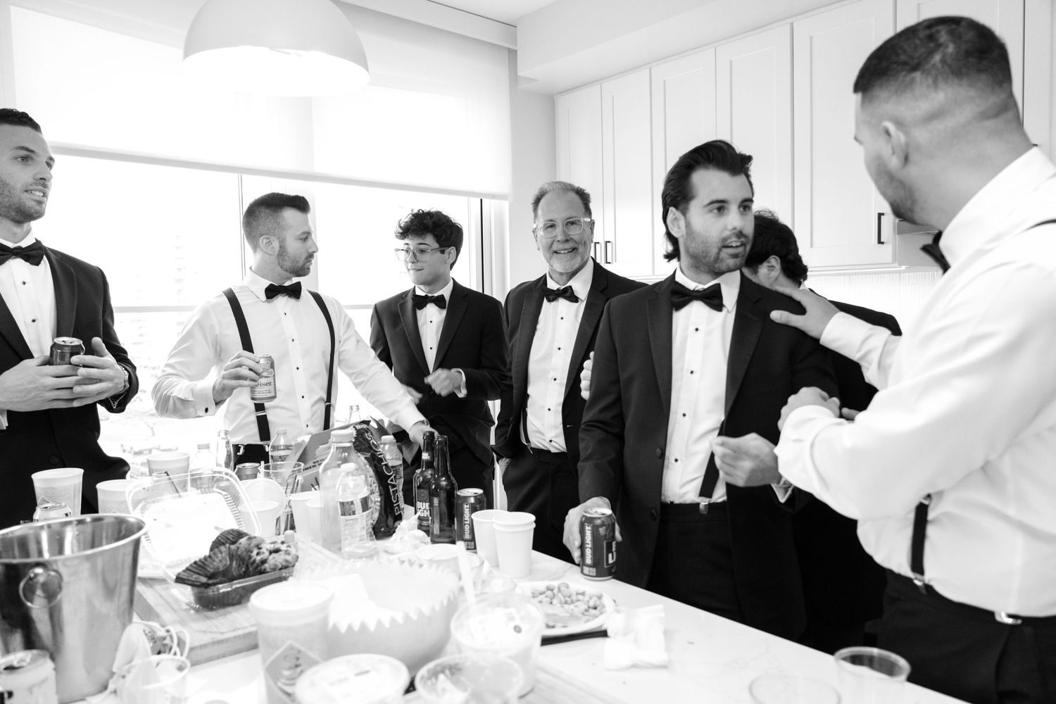 Wedding guests enjoying conversation and laughter at an elegant reception table in formal attire.