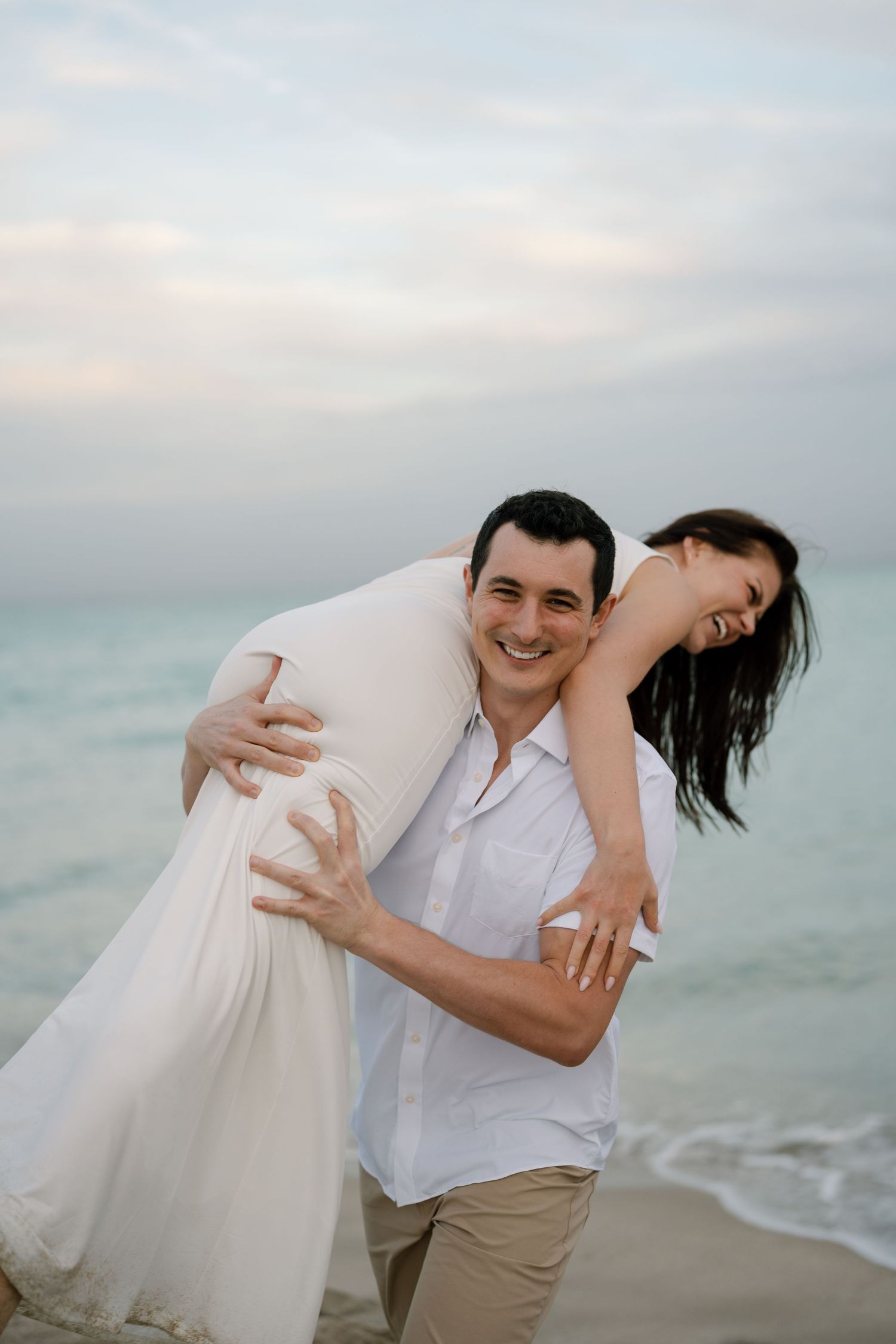Candid beach photography sequence showing couple in white and khaki dancing on shoreline.
