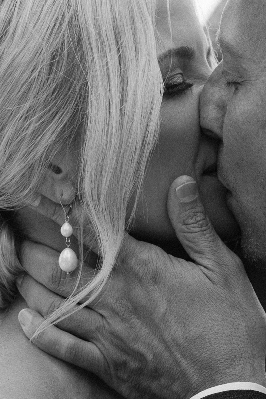 Intimate black and white close-up portrait showing pearl earring and tender moment.