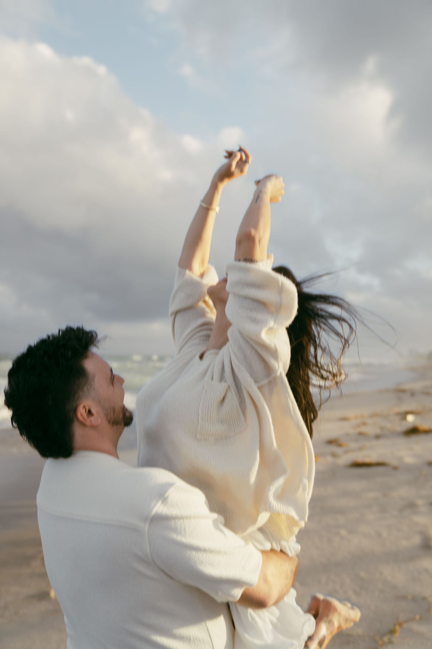 A series of photos shows a person in white clothing expressing joyful movement against a cloudy beach backdrop.