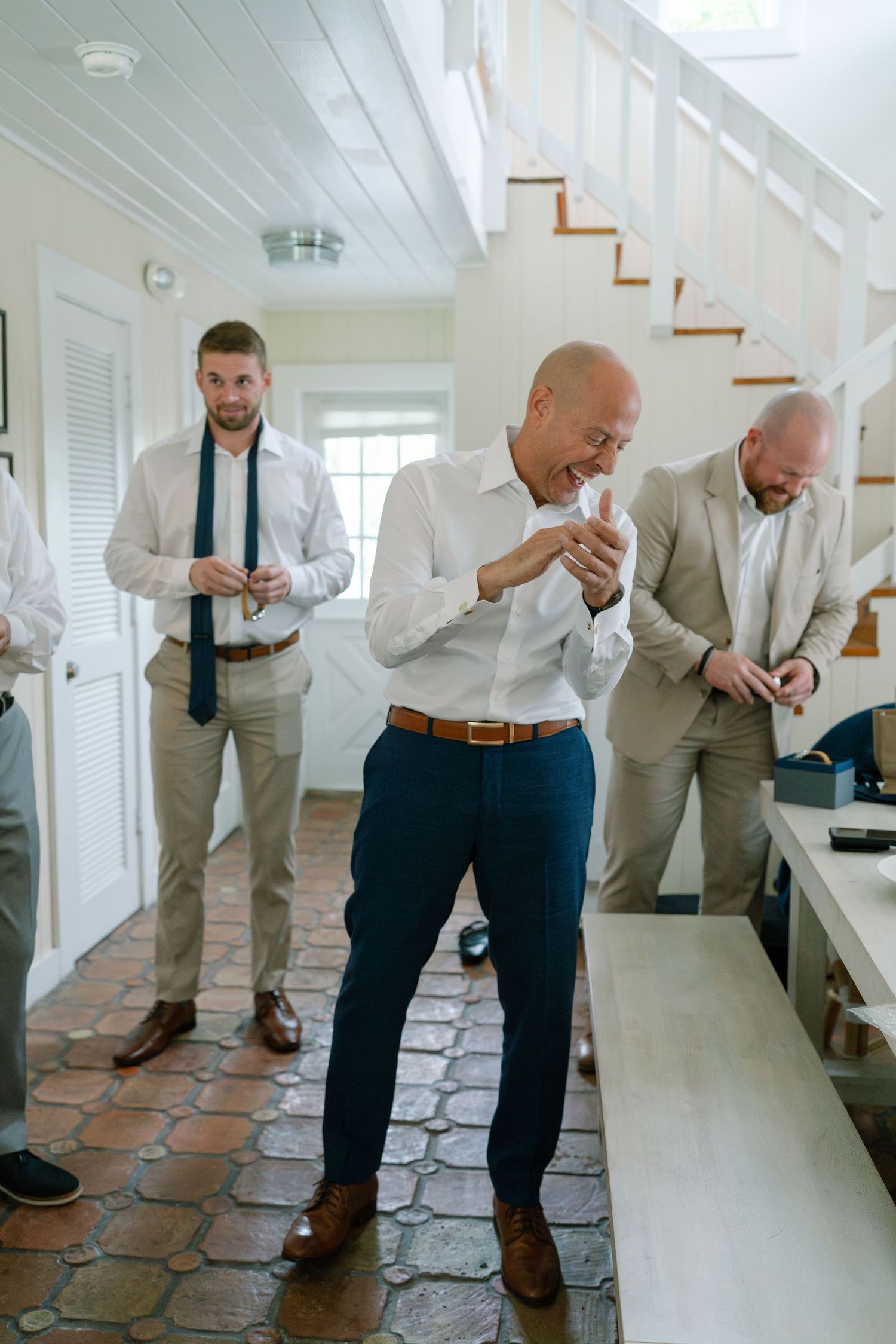 A series of photos showing groomsmen in light gray suits laughing and sharing a humorous moment together.
