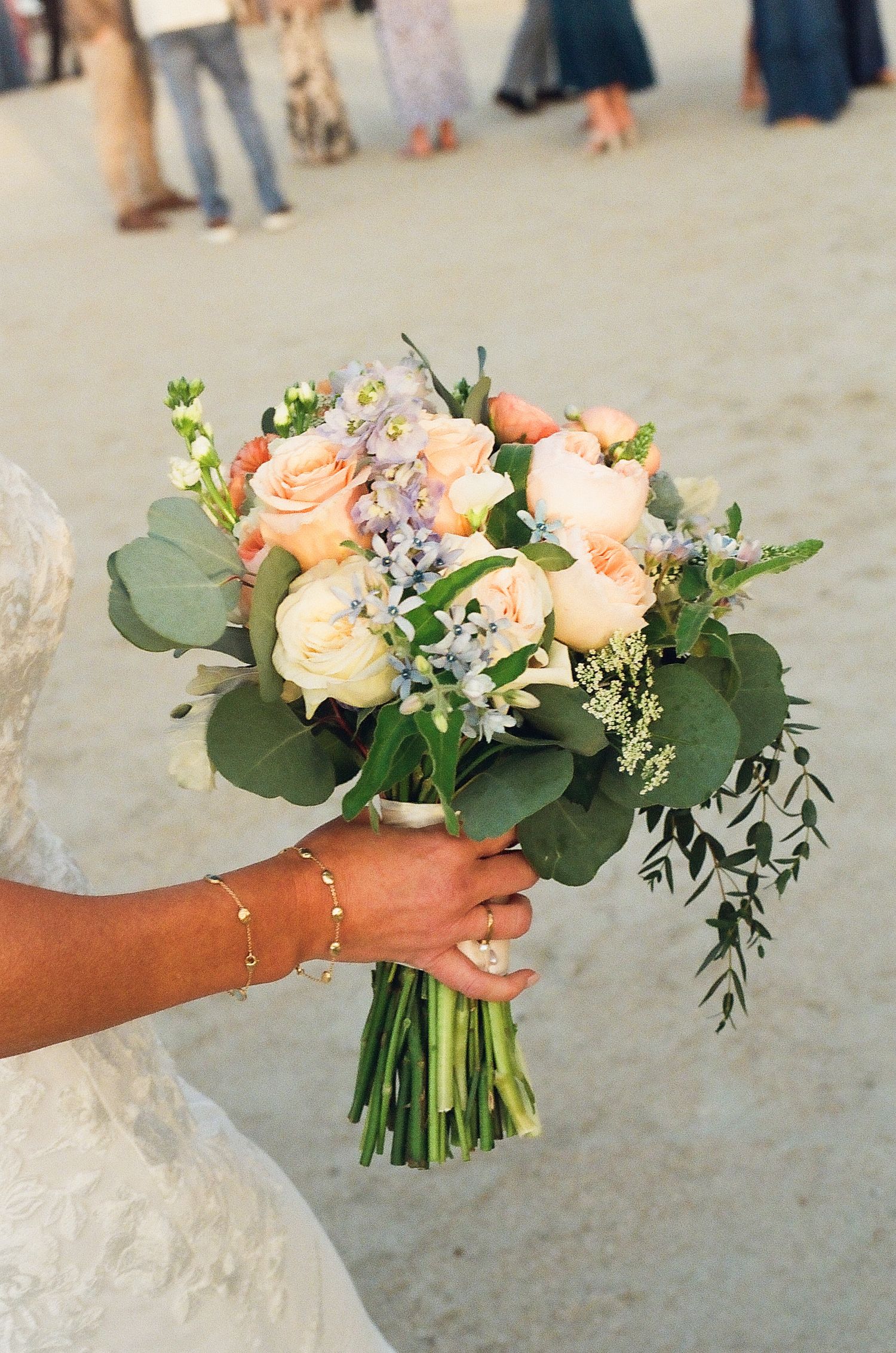 Elegant bridal bouquet featuring peach roses and eucalyptus leaves.