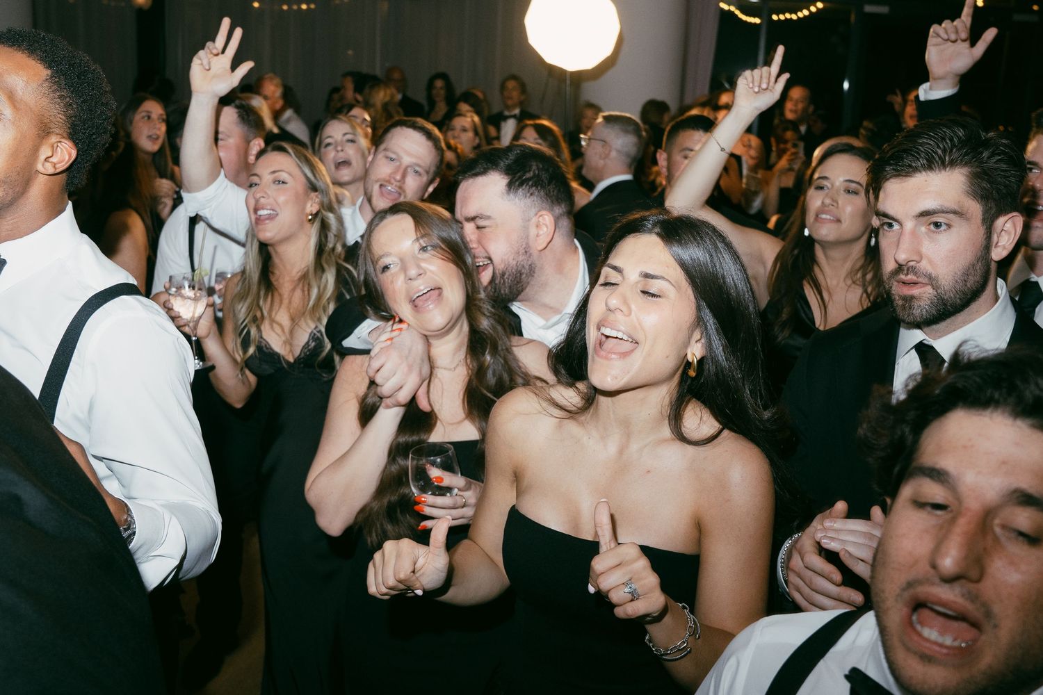 Lively dance floor scene with wedding guests celebrating during the reception party.