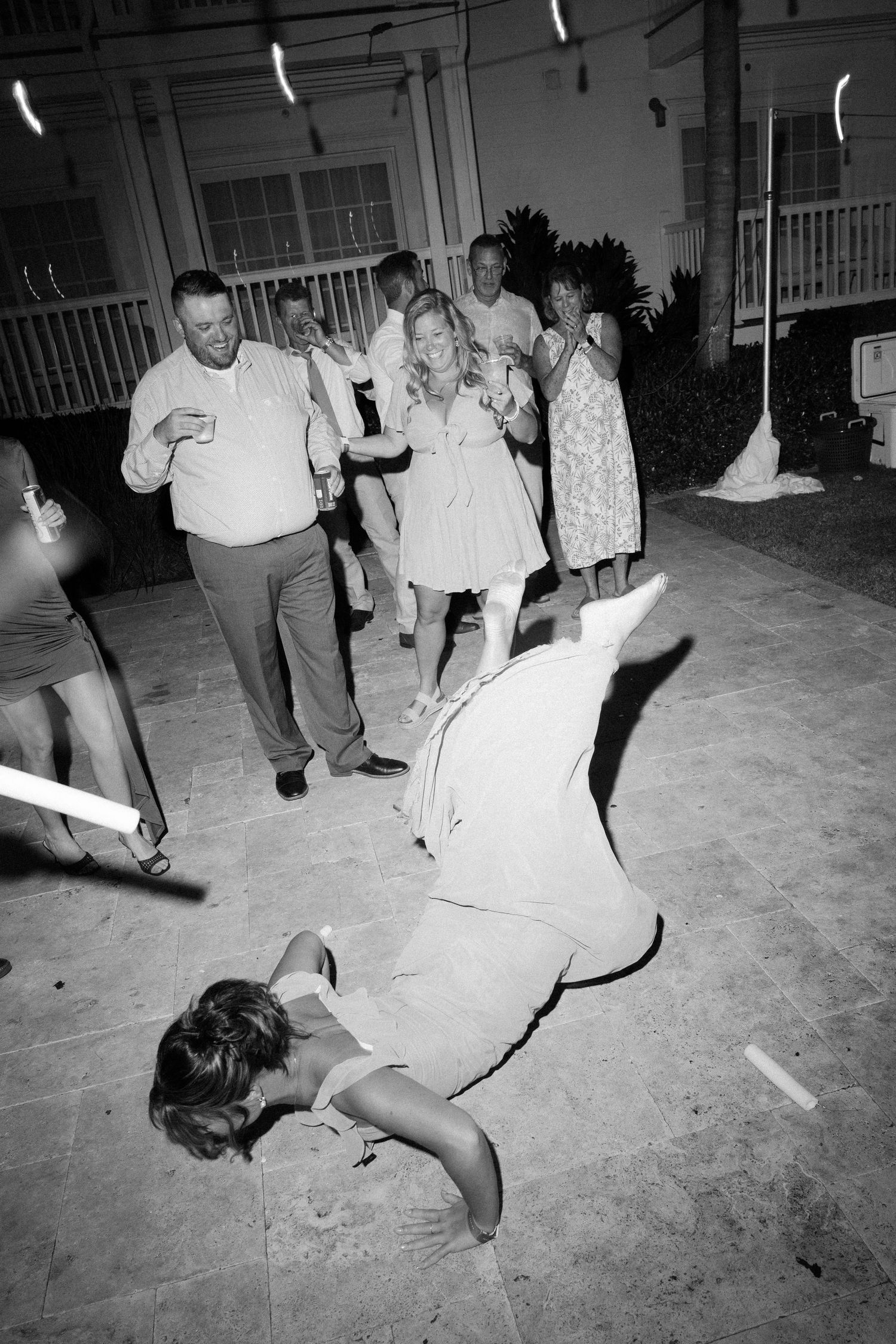 Sequence of black and white photos showing people dancing and falling on a patio.