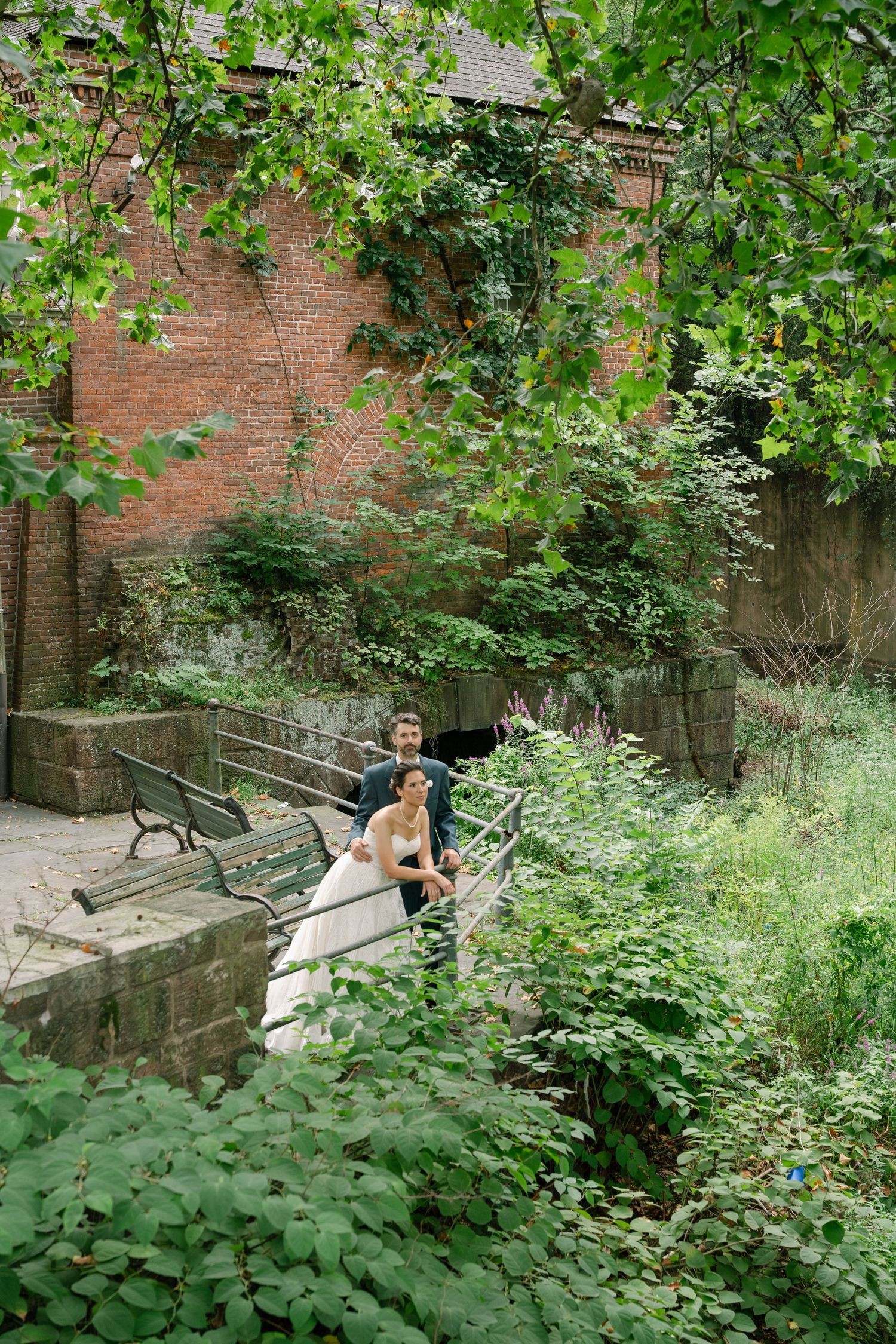 A series of outdoor garden steps surrounded by lush greenery and brick walls in a secluded setting.