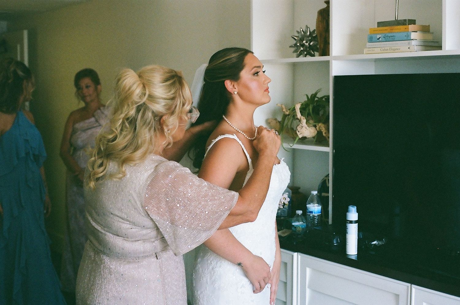 Two people embrace in a tender moment while standing in a bright kitchen interior.