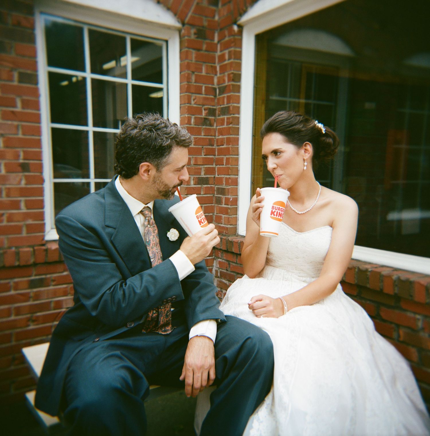 Series of candid wedding moments showing a couple sharing coffee together in front of a brick wall.