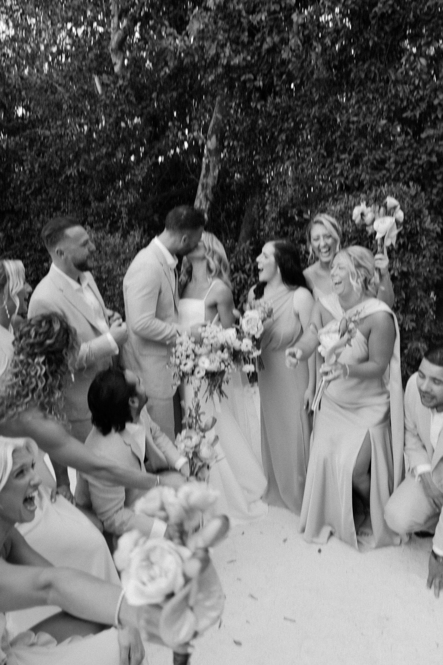 A black and white photo series showing a wedding party celebration outdoors.