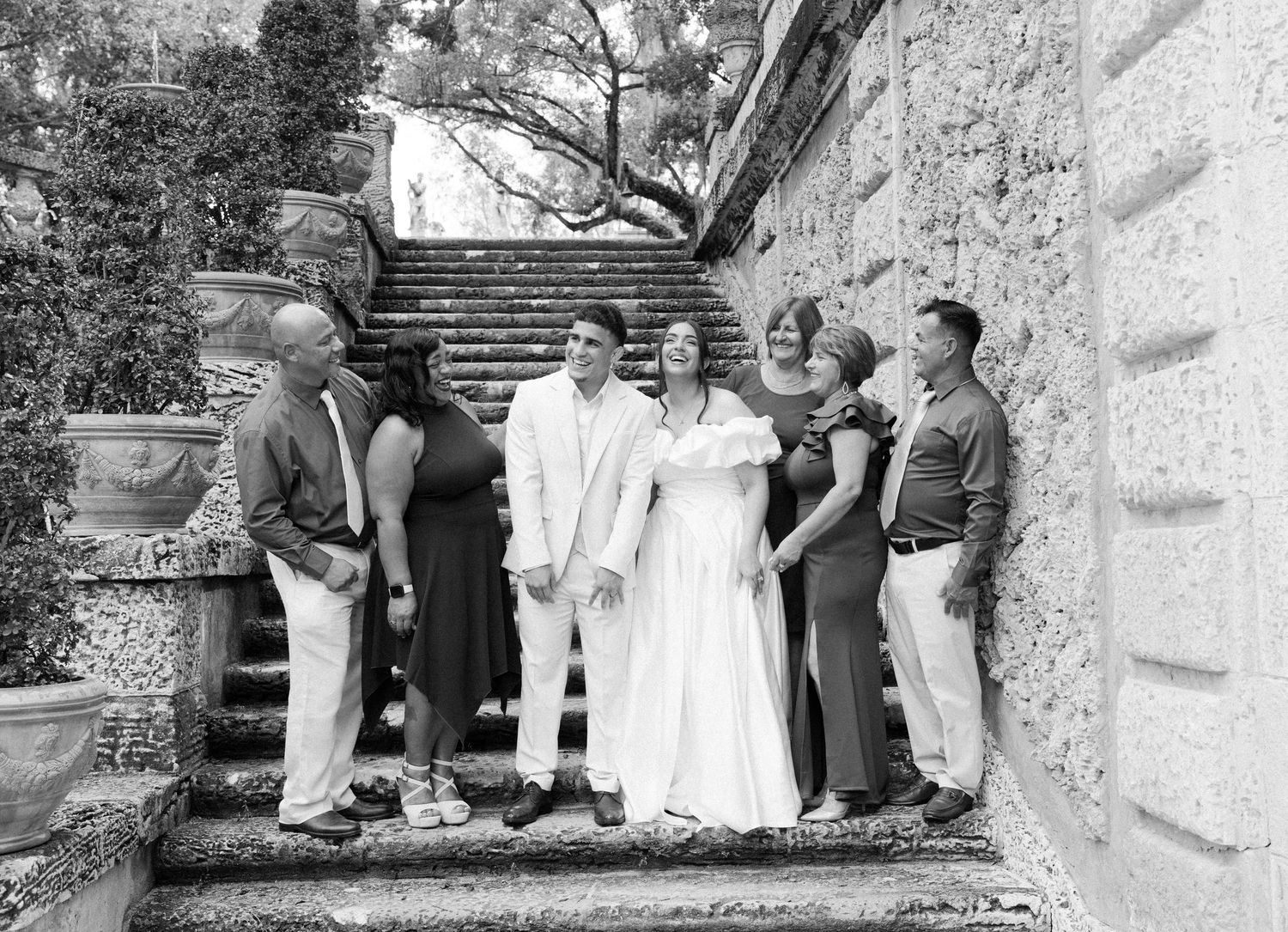 A vintage black and white photograph showing a group of people gathered on stone steps outside a building.