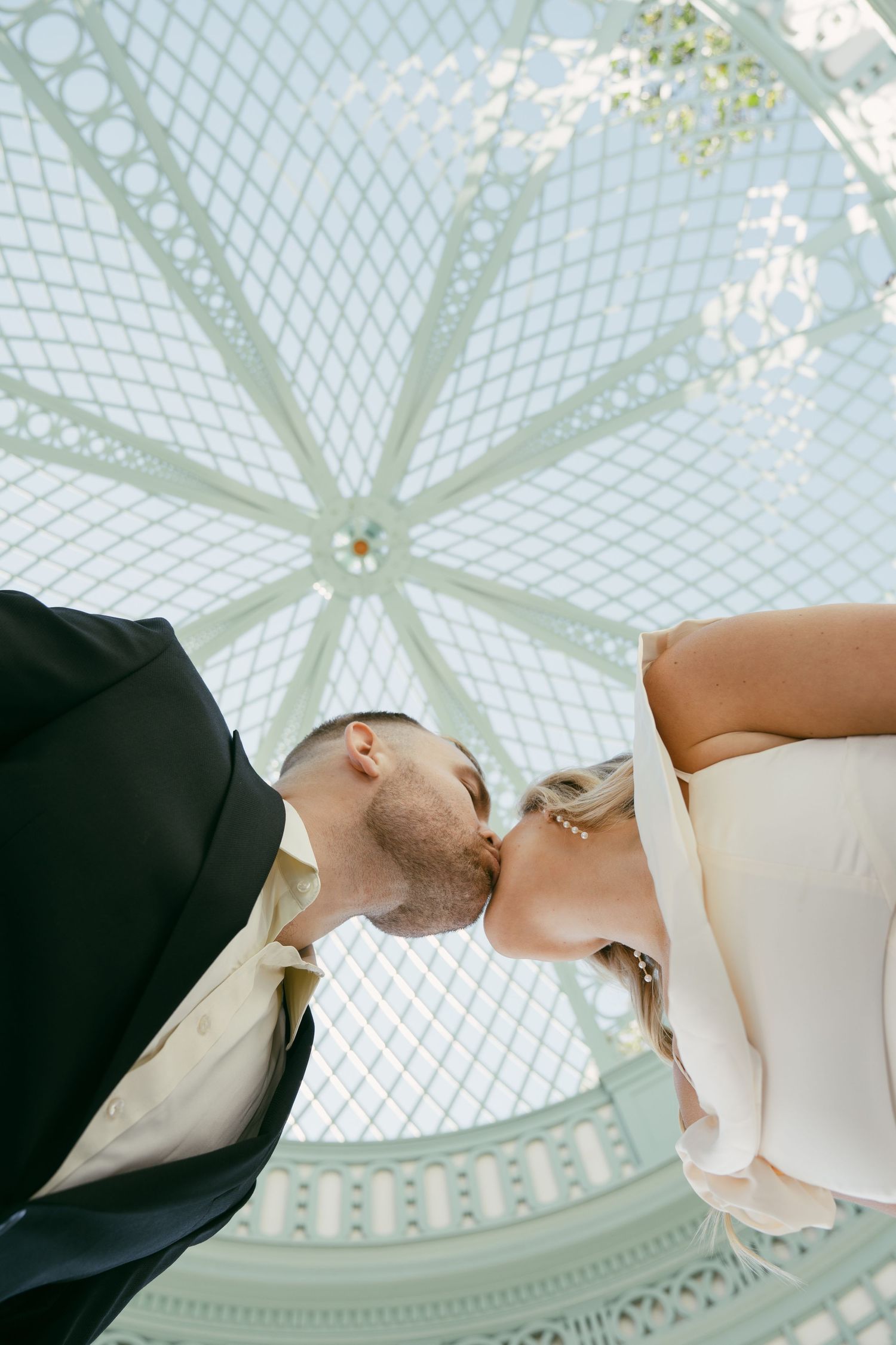 A sequence of romantic wedding photos showing couples holding hands against a domed glass ceiling backdrop.