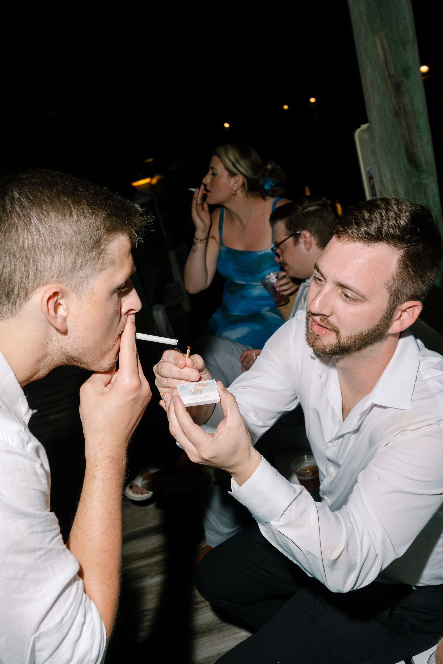 A group of people socializing and enjoying drinks together at an outdoor party.