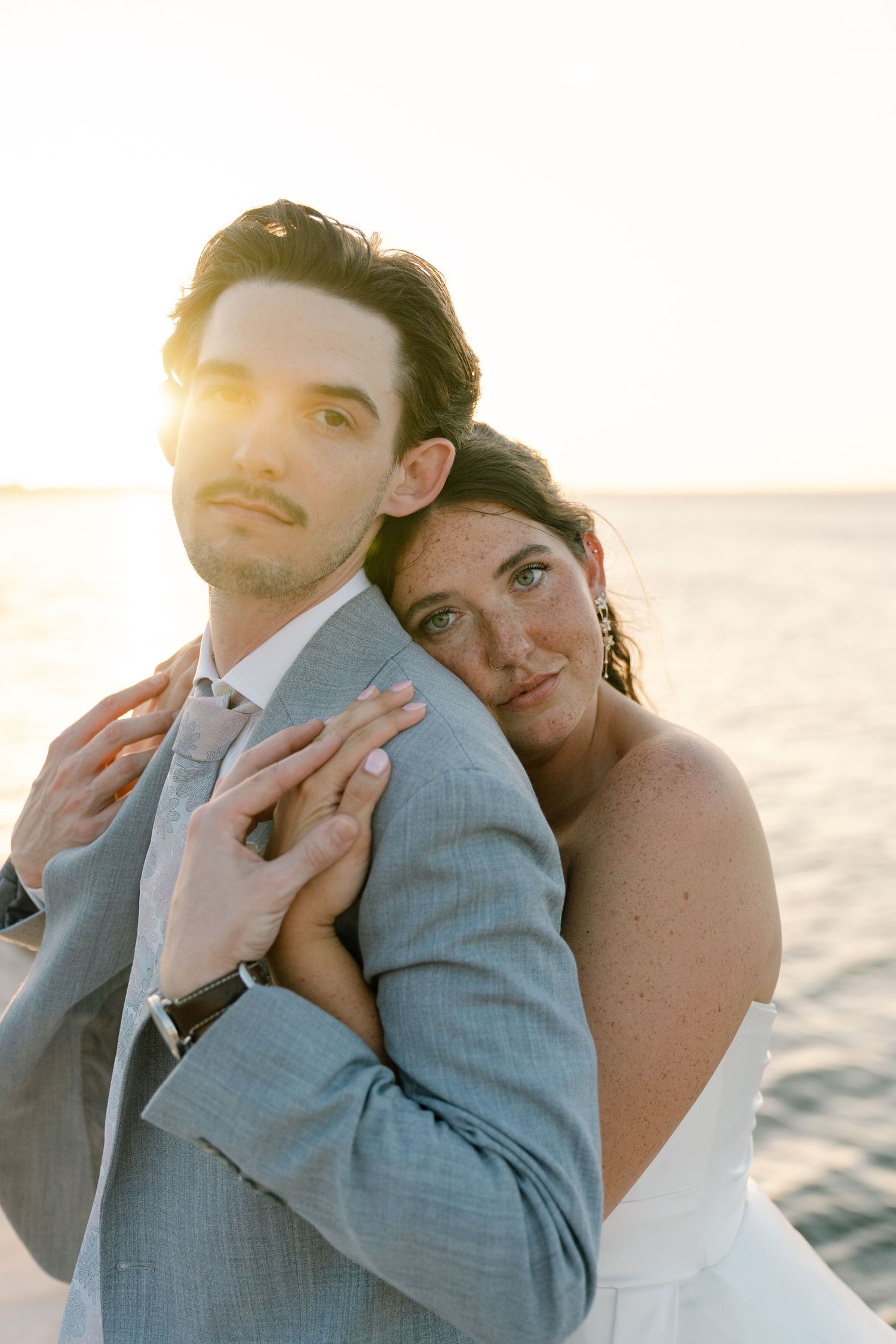 A couple embracing on a beach at sunset.