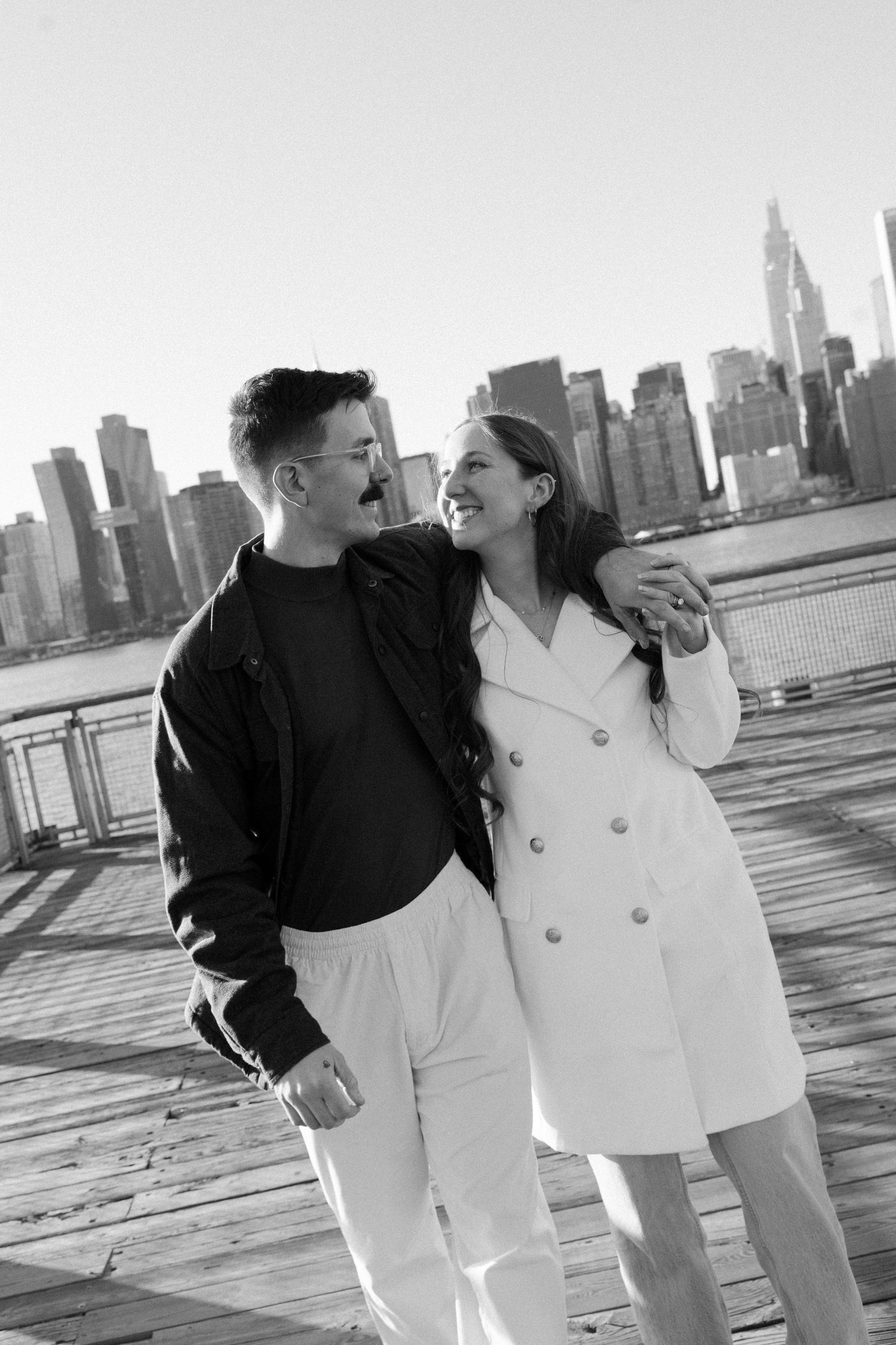 A romantic black and white photo series showing a couple in matching black and white outfits against a city skyline.