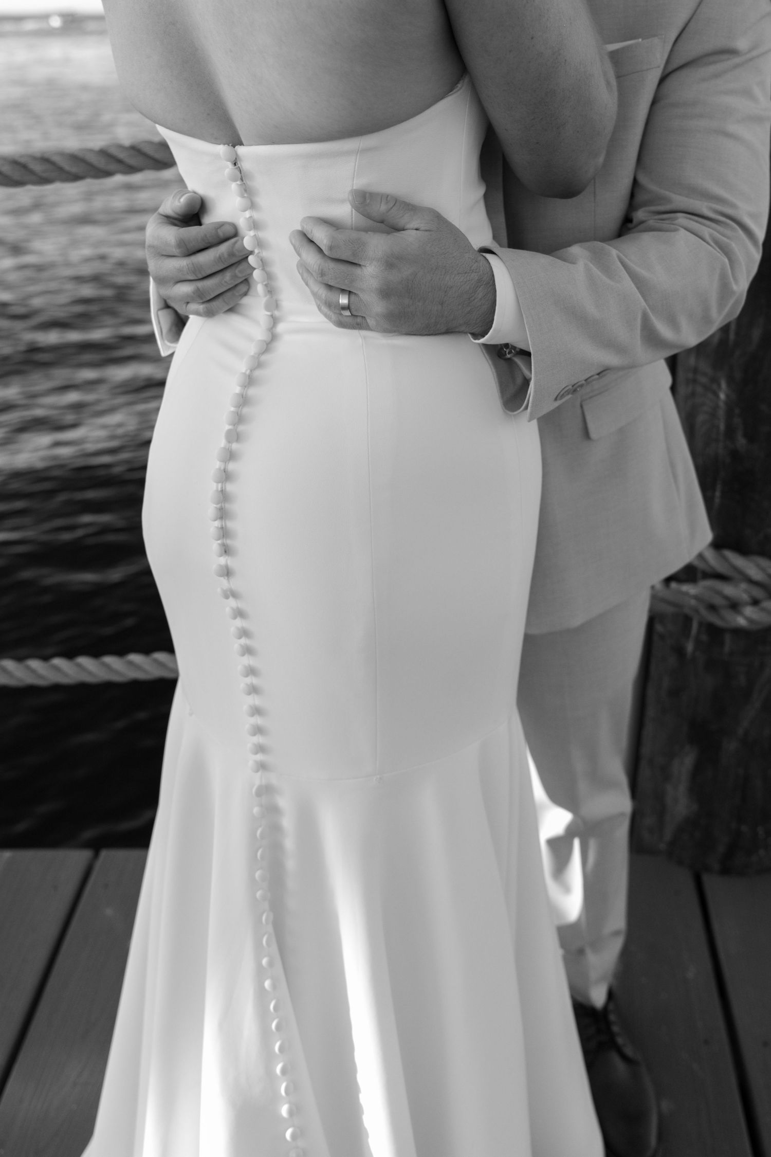 Close-up details of white wedding dress buttons along the back.
