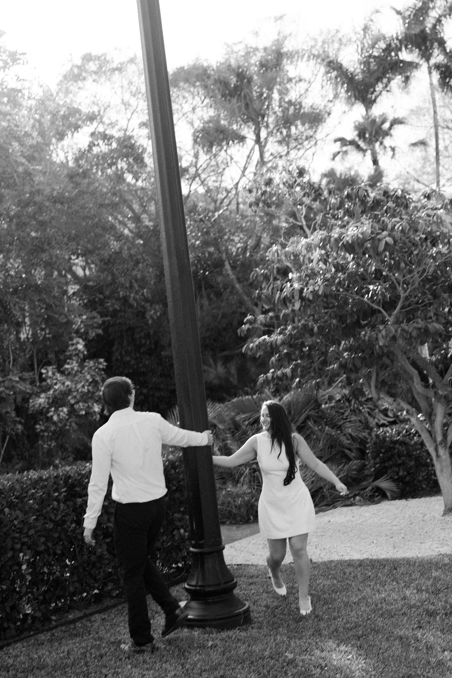 Black and white photo sequence shows three people holding hands and walking through a garden path.