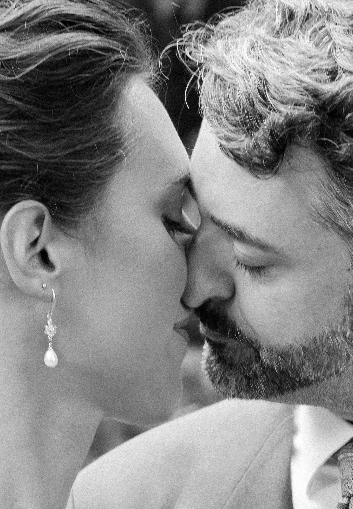 A black and white series of intimate close-up shots showing a tender romantic moment between two people.