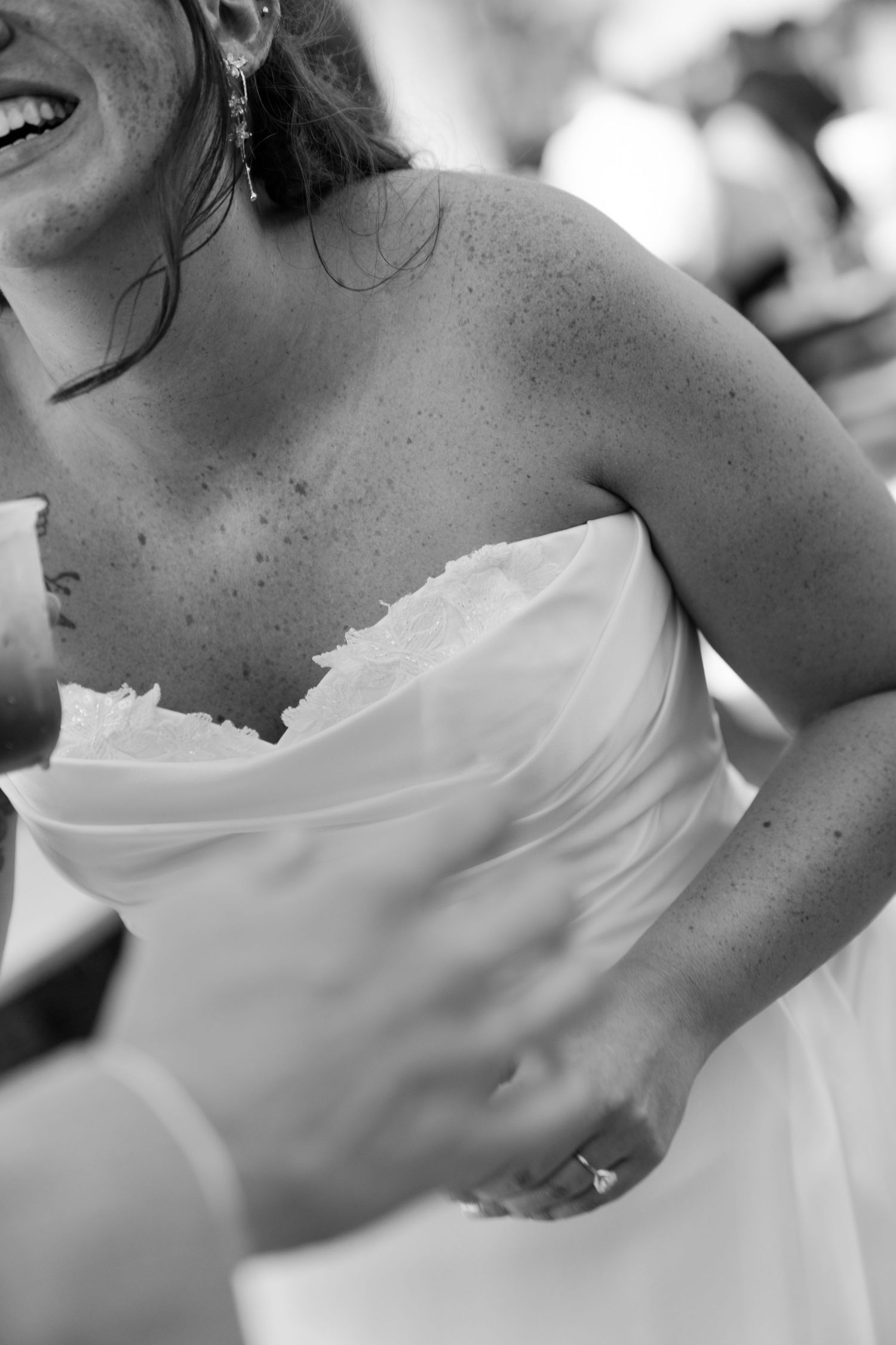 A close-up portrait of a smiling woman in a wedding dress.