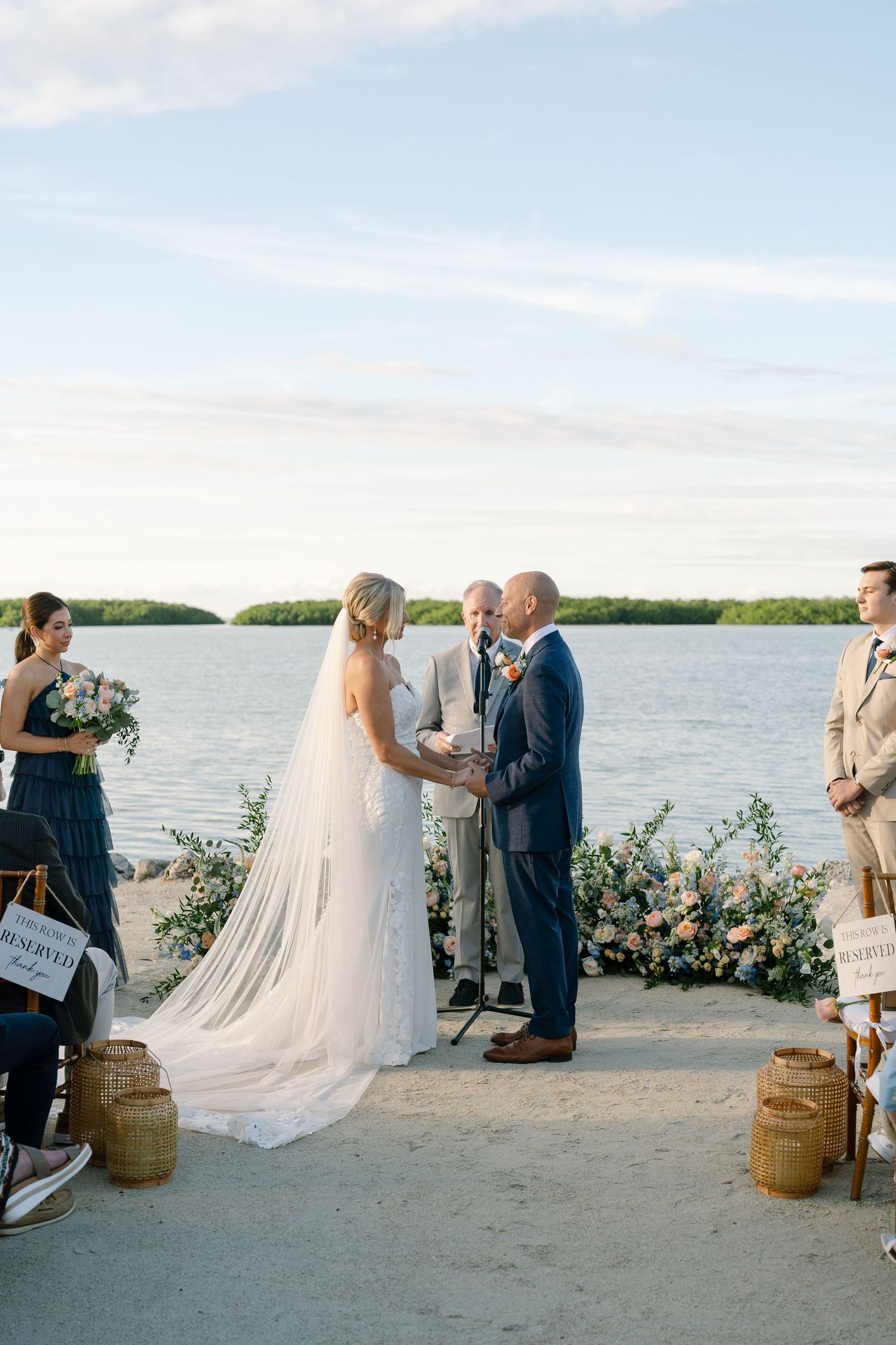 A waterfront wedding ceremony with floral arrangements and rustic wooden decor.