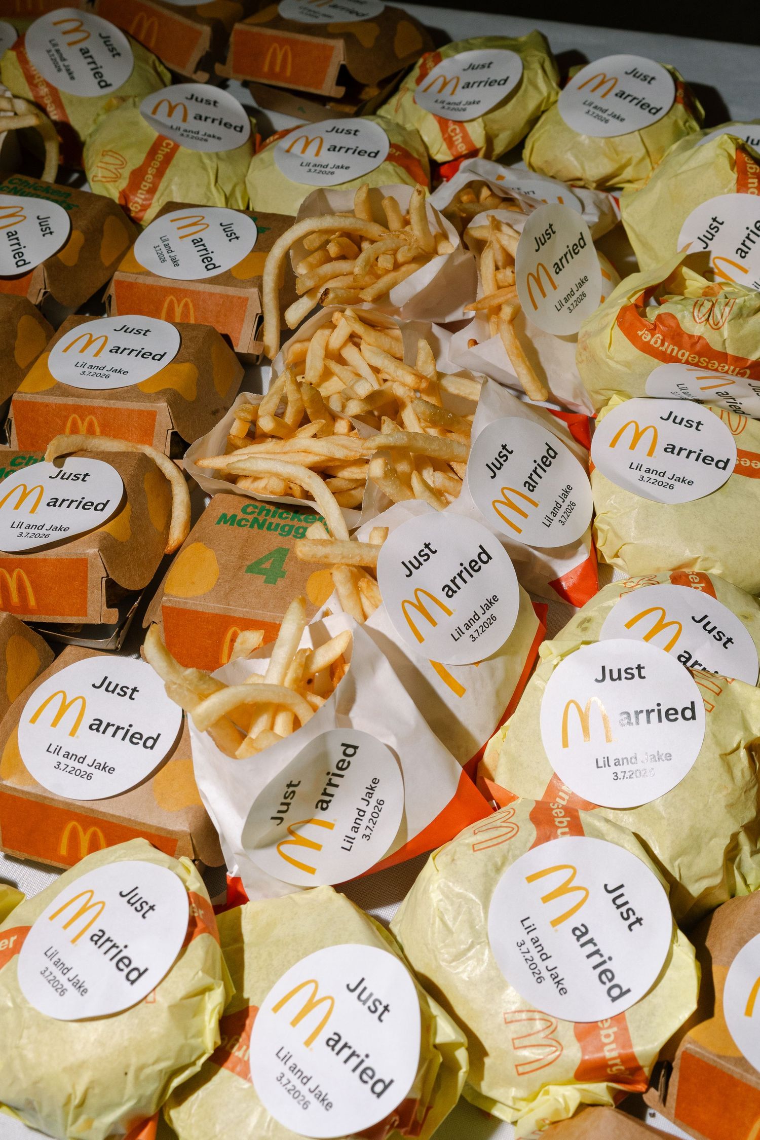 An assortment of McDonald's fast food items, including french fries and hamburgers, with 'Just Arrived' stickers on the packaging.