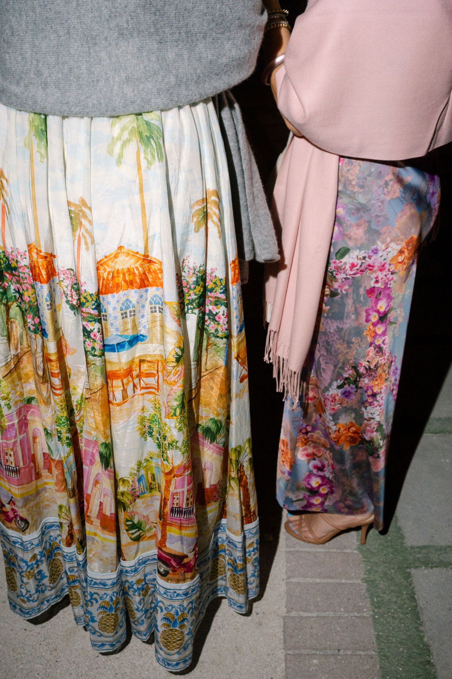 Colorful floral and scenic printed skirts displayed in a row showing detailed landscape patterns.