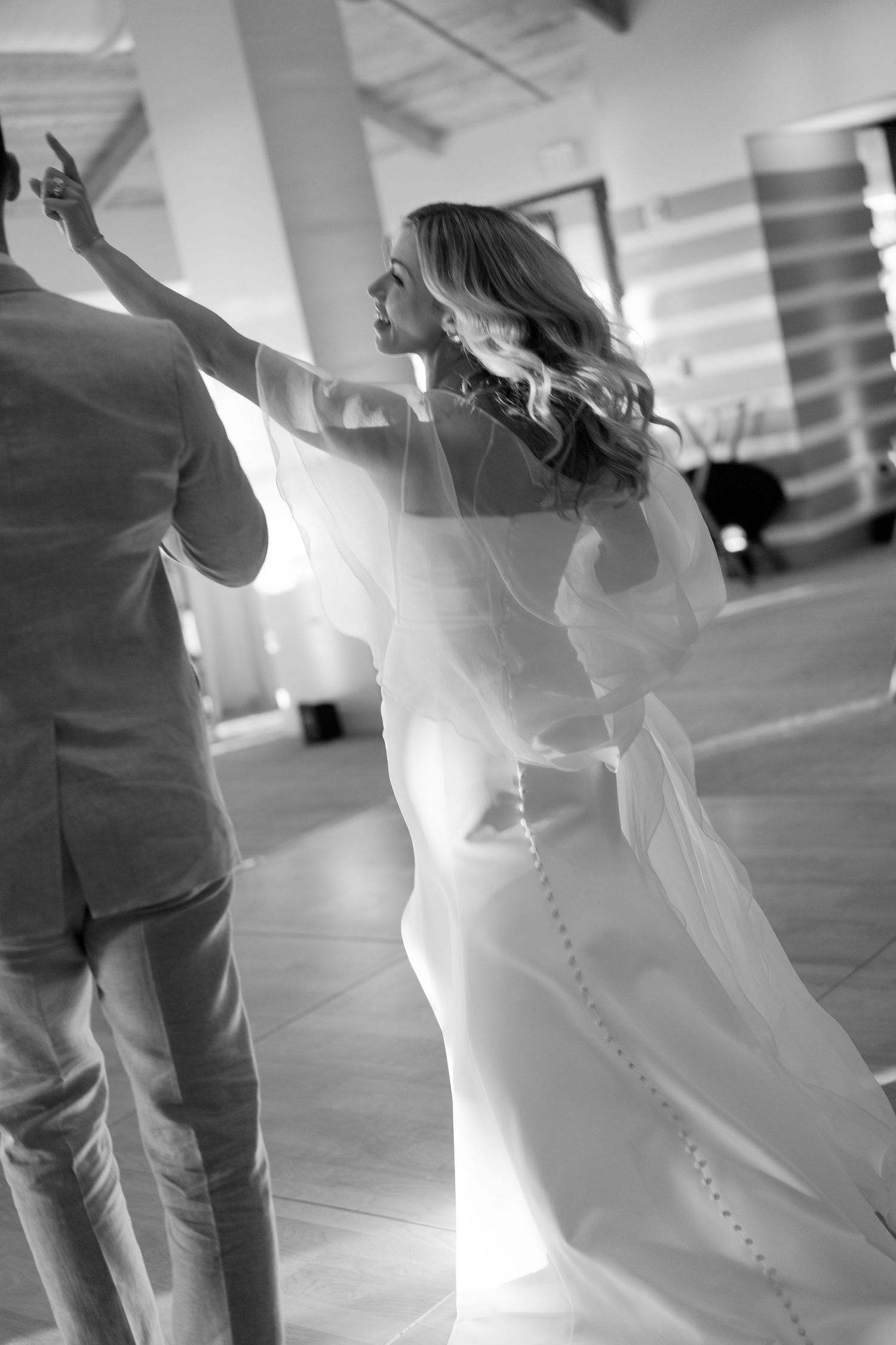 Dance floor moments captured in soft black and white during wedding reception.
