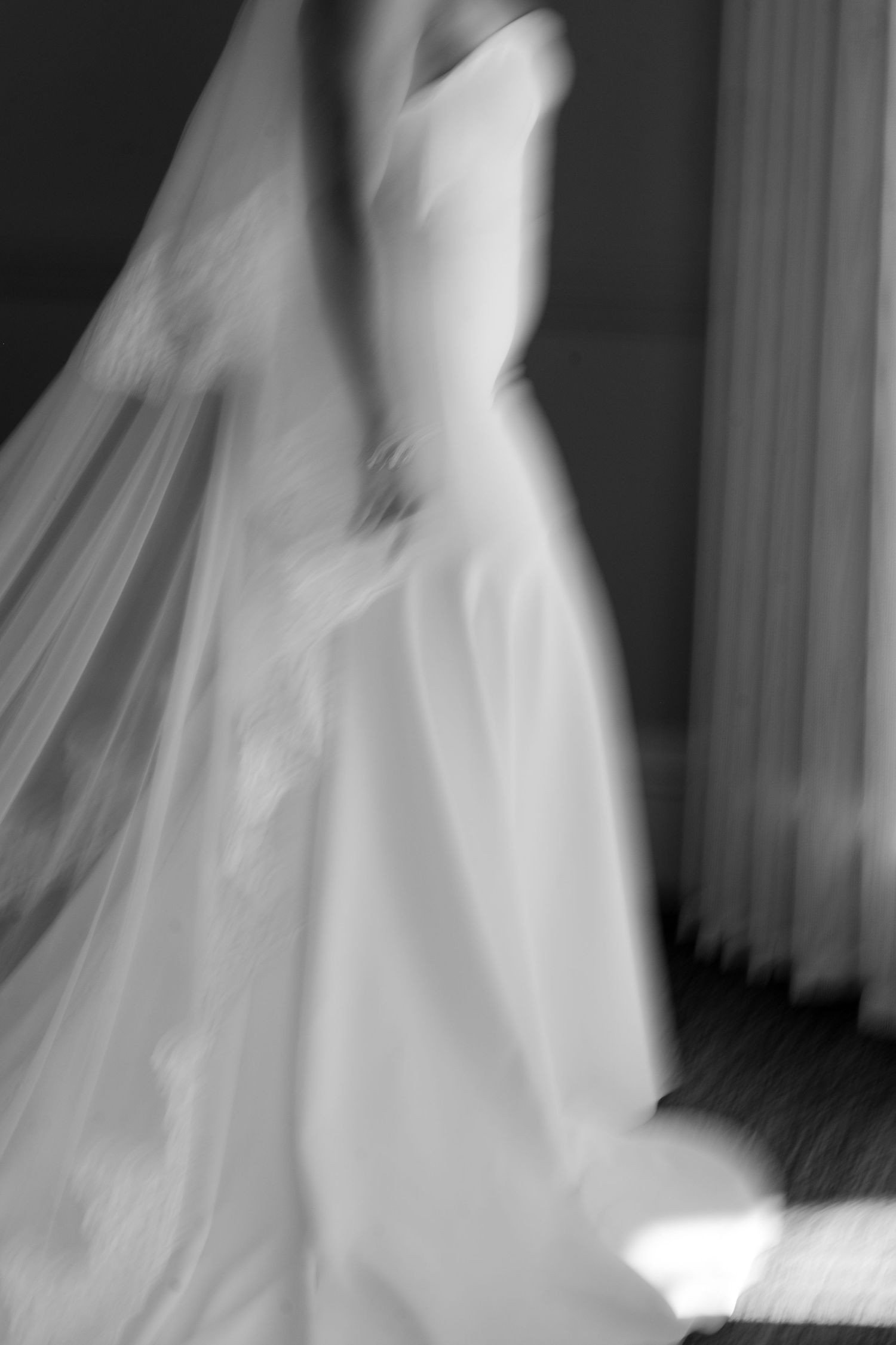 Ethereal flowing white wedding dress captured in artistic motion blur sequence.