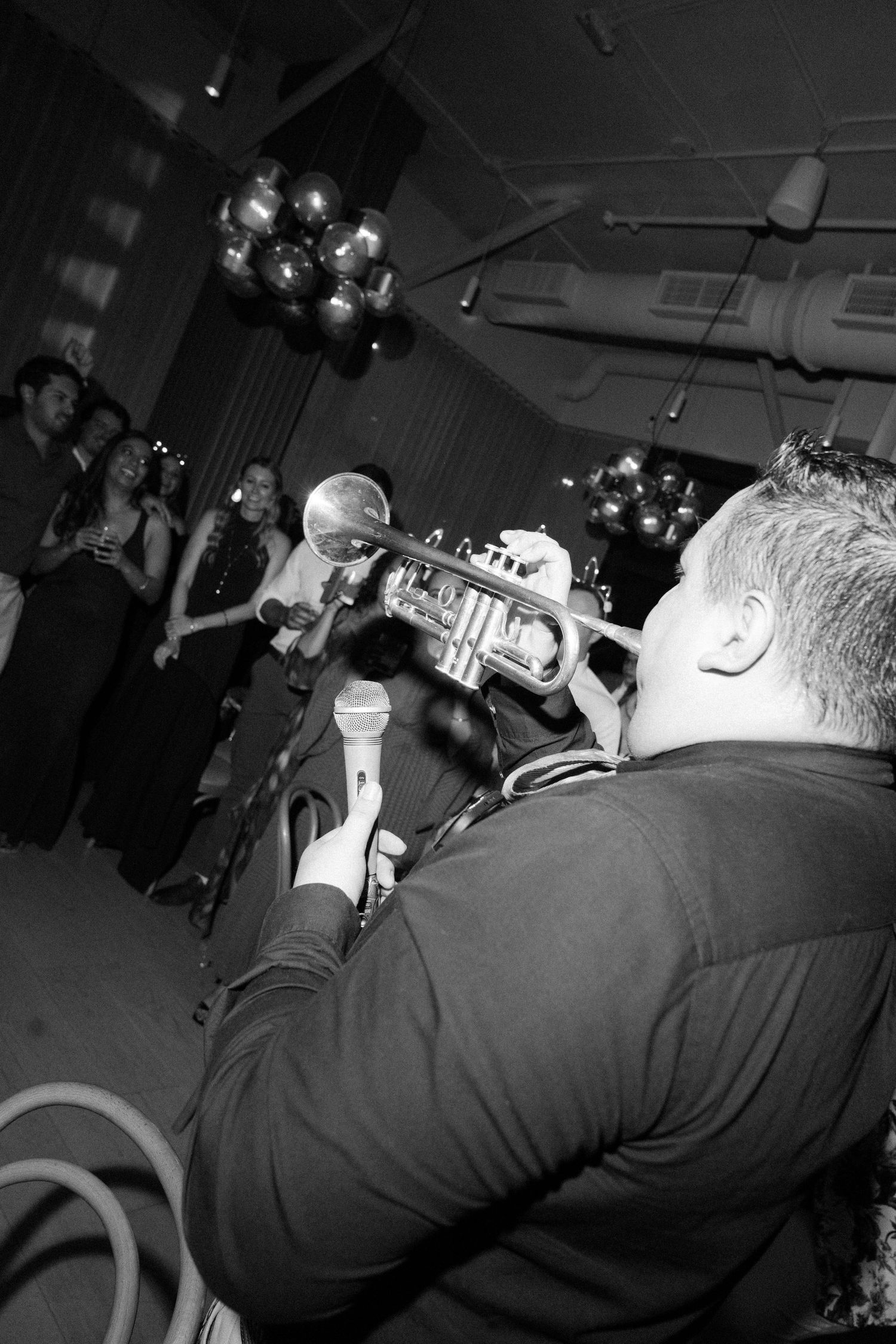 Black and white photos of trumpet players performing at a musical event in sequence.