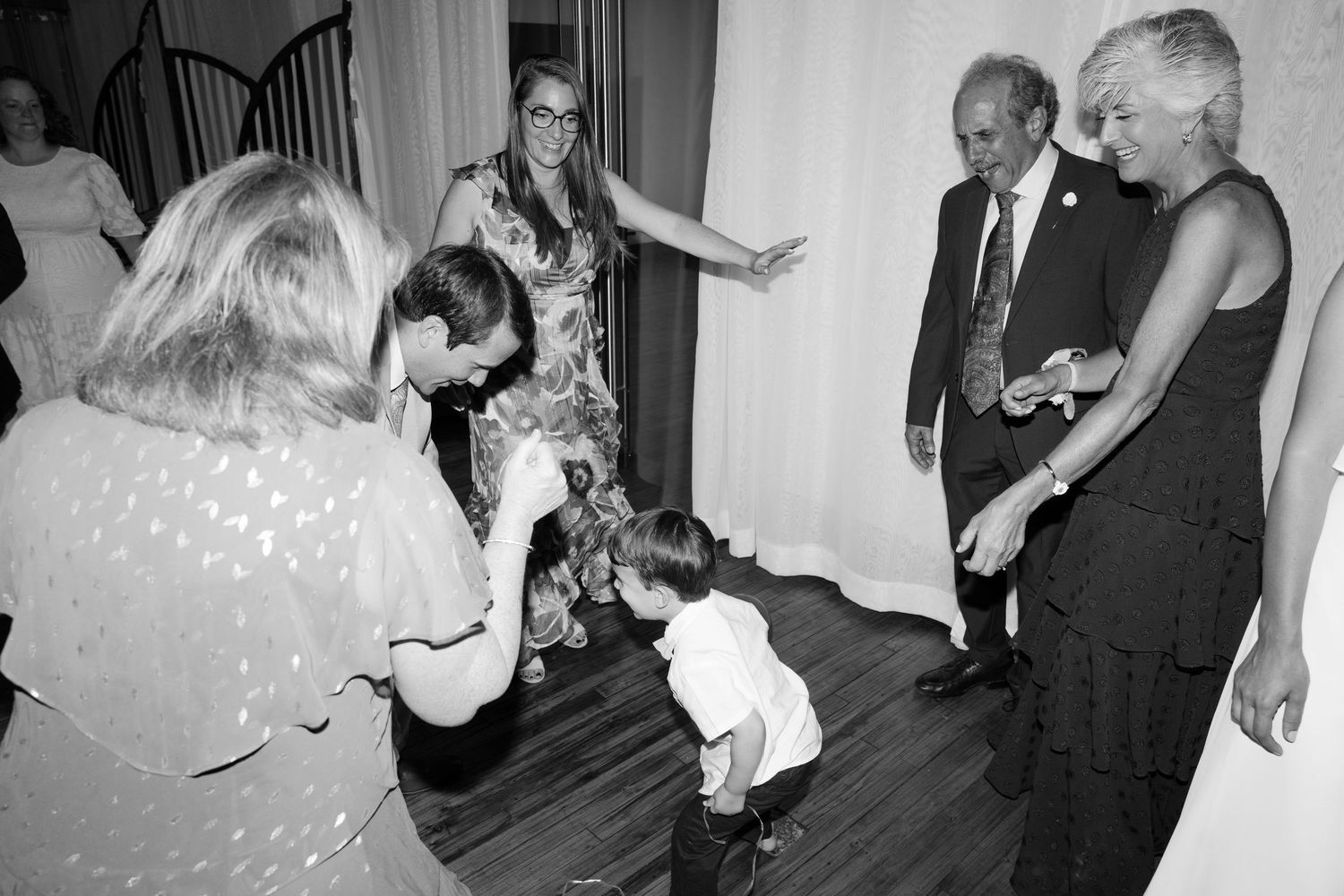 Black and white photos of wedding reception dancing with guests celebrating on the dance floor.