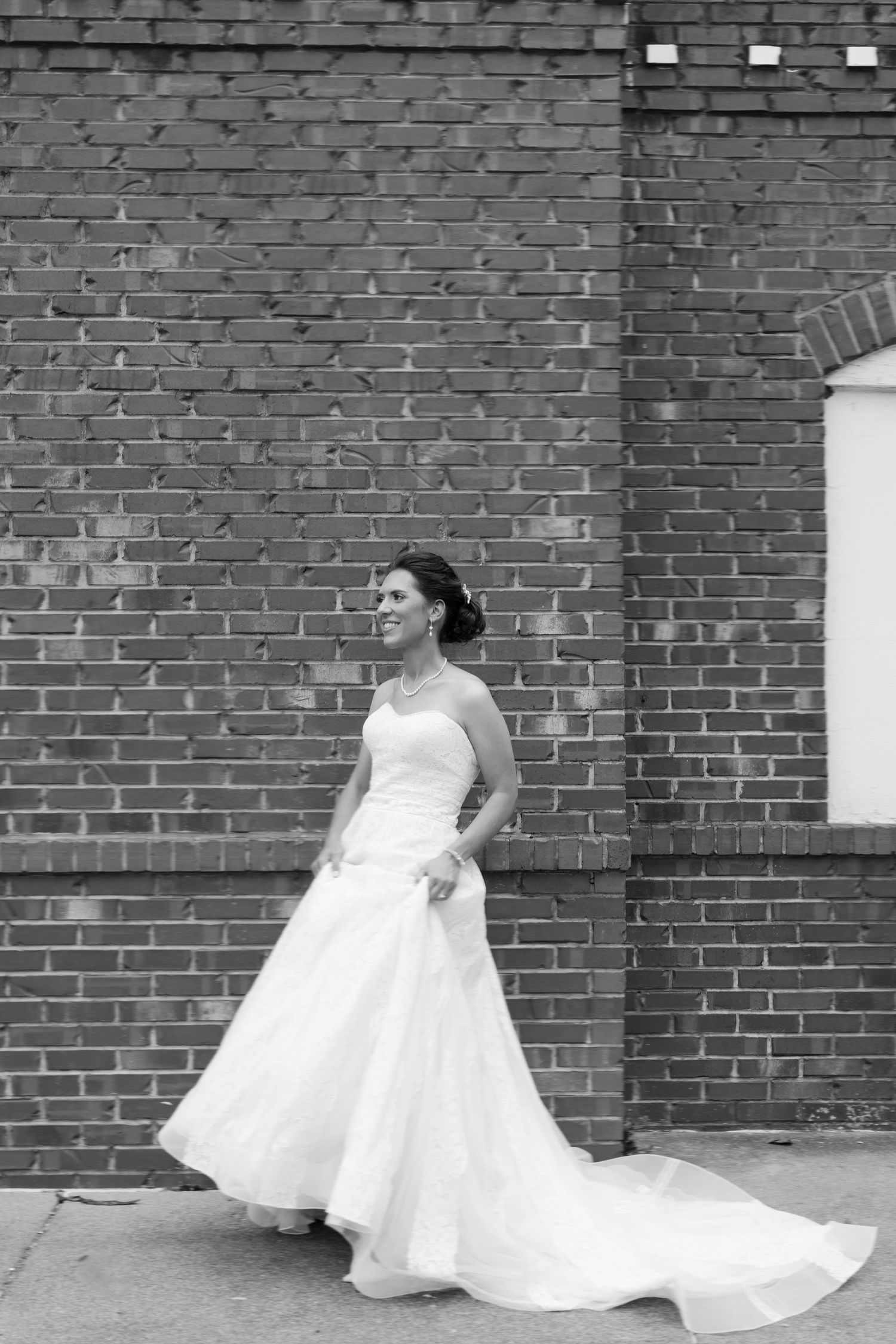 A series of black and white photos showing a bride in white dress against a brick wall background.