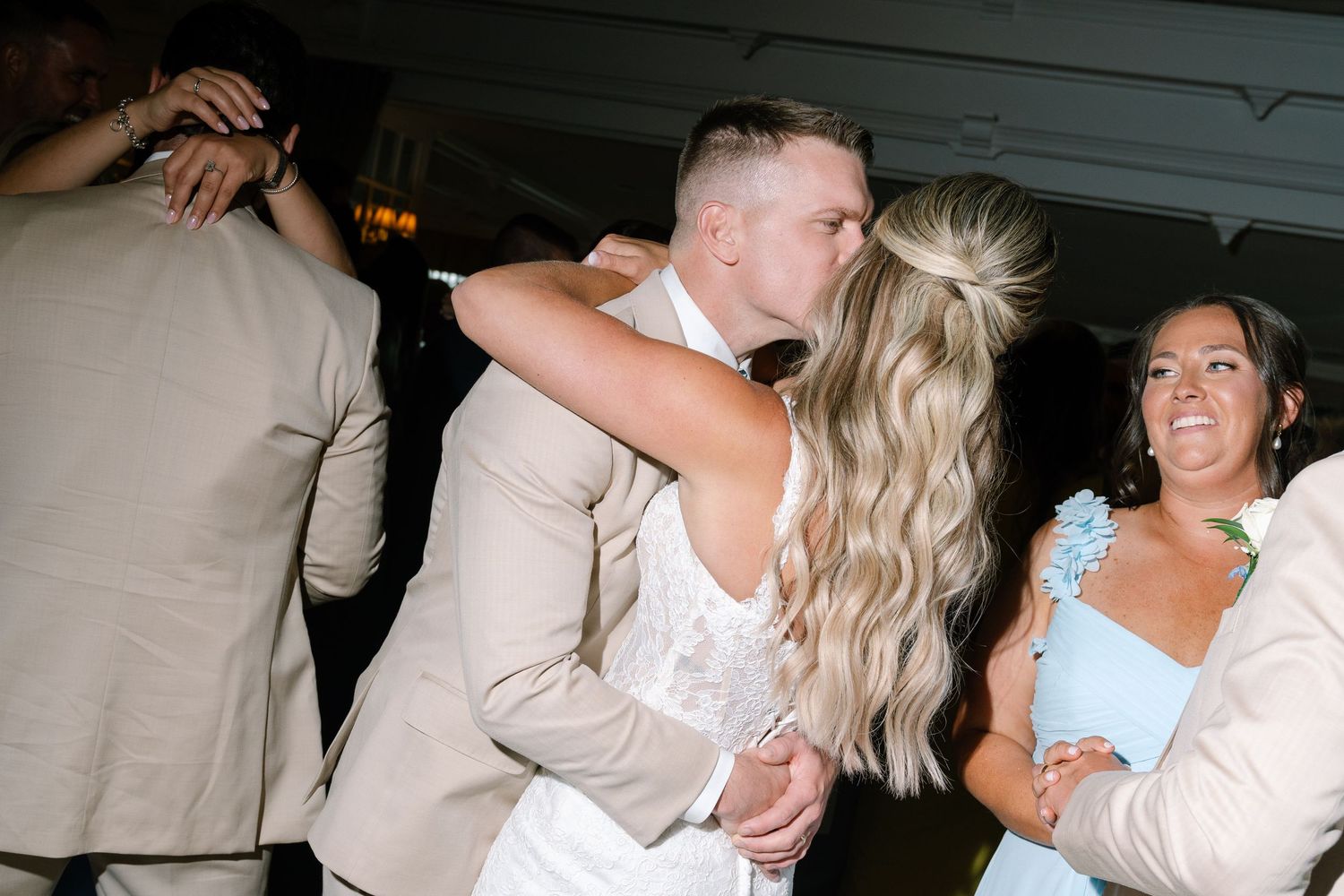 Bride and groom share a romantic kiss on the dance floor during their wedding reception.