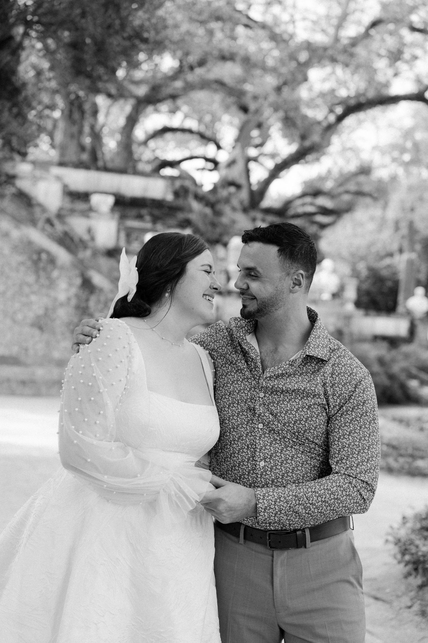 Intimate black and white portrait series captured outdoors under tree canopy.