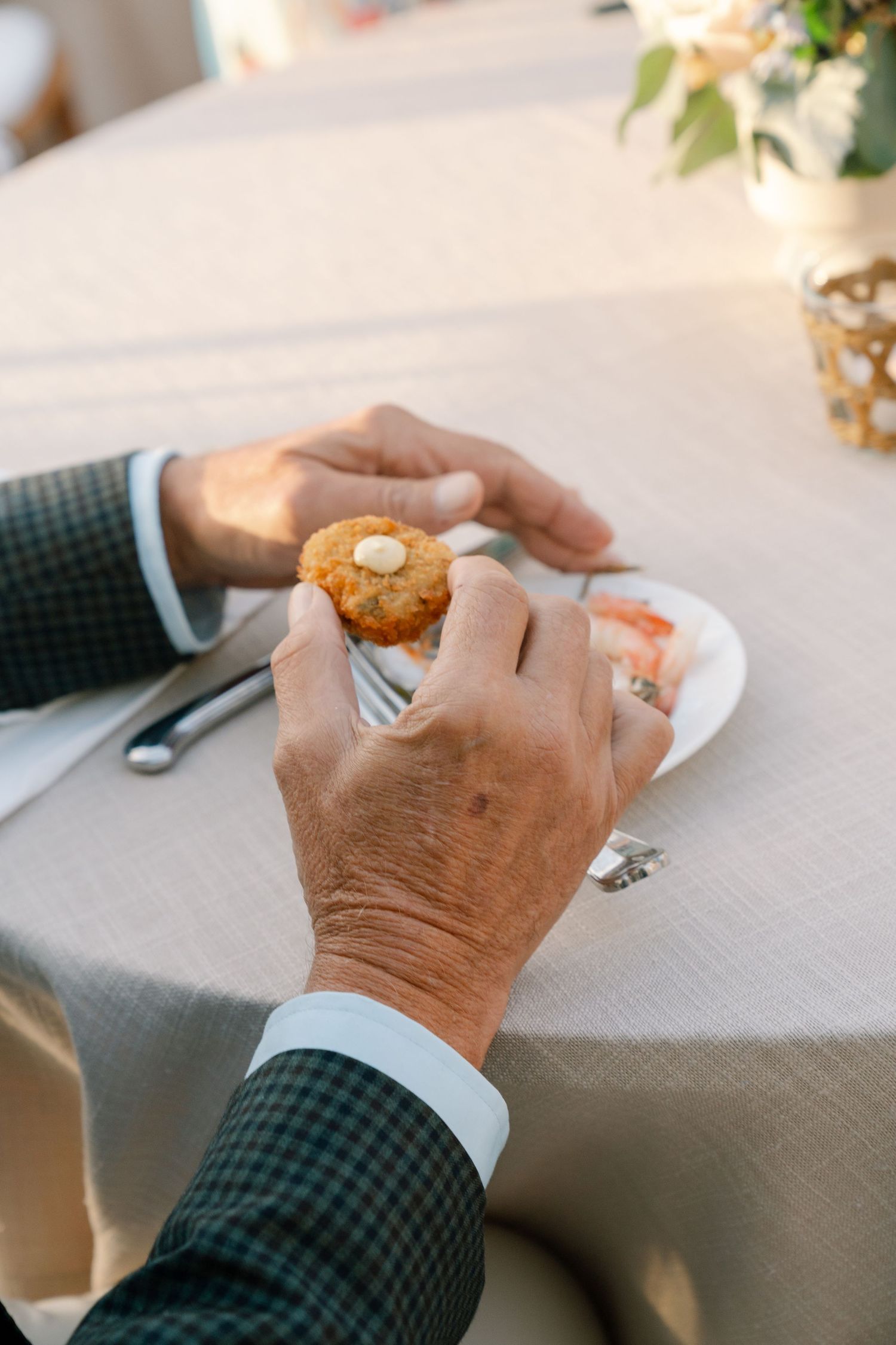 Hands holding desserts at an elegant wedding reception table.