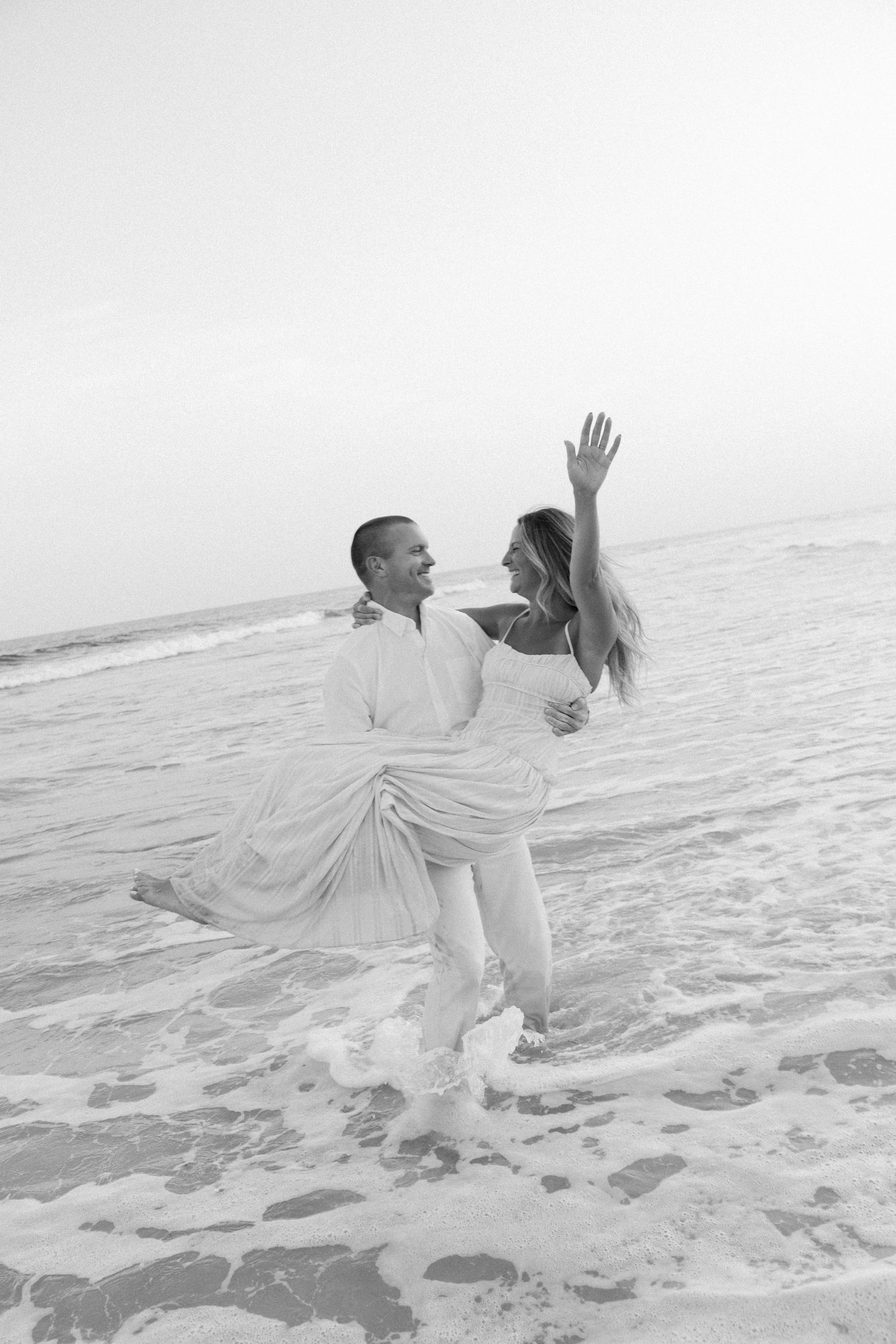 A romantic sequence of black and white photos showing a couple dancing and spinning on a misty beach.
