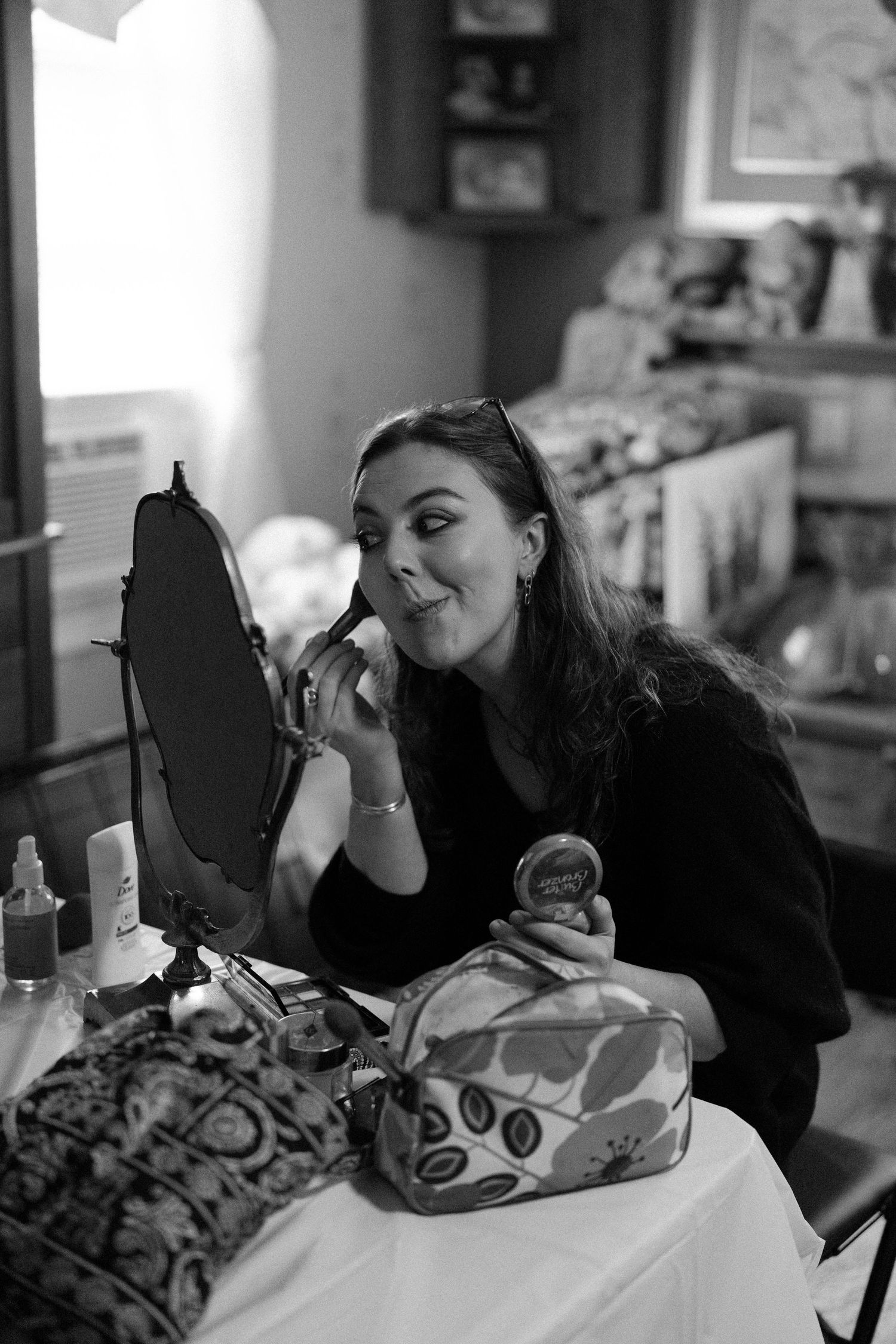 Black and white candid photos showing joyful moments during wedding day preparations.