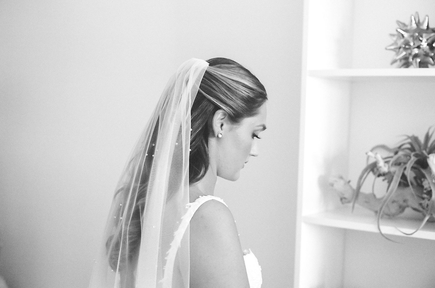 A collection of black and white wedding photos showing bridal details like veils and hair styling arranged in a grid.