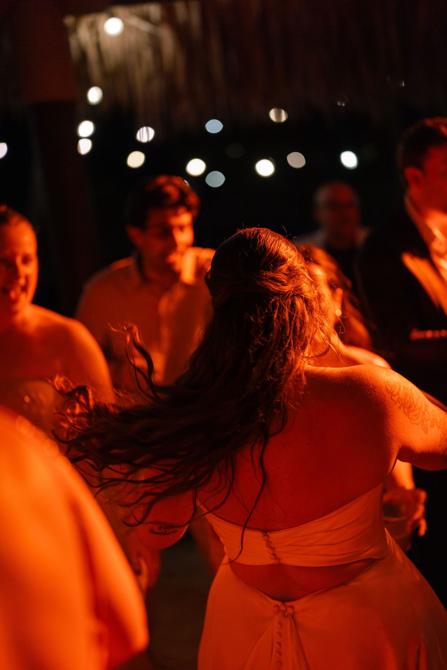 A crowd of people dancing at a nightclub, with colorful lights and blurred figures in the background.