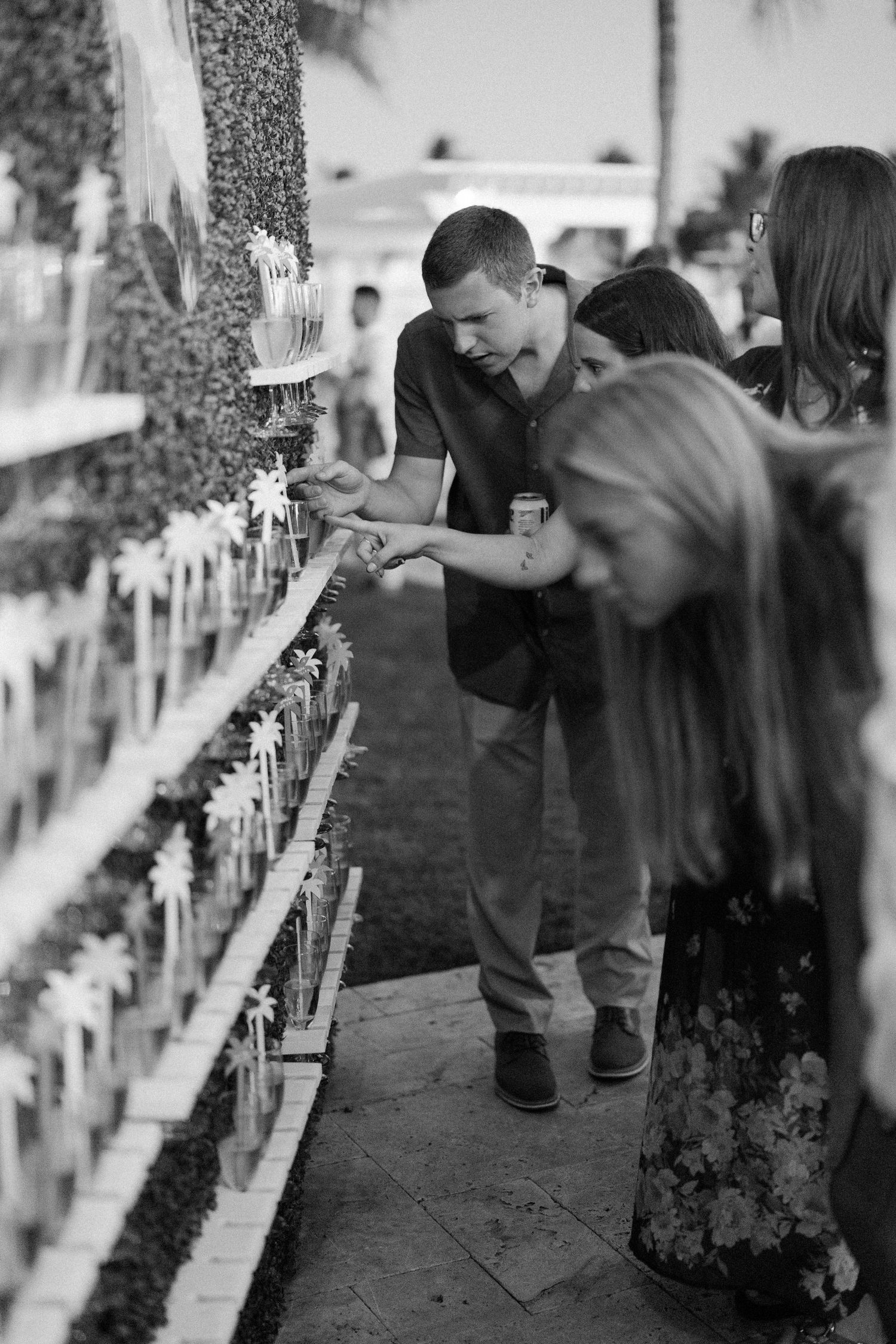 People examining a display of small bottles at an outdoor event.