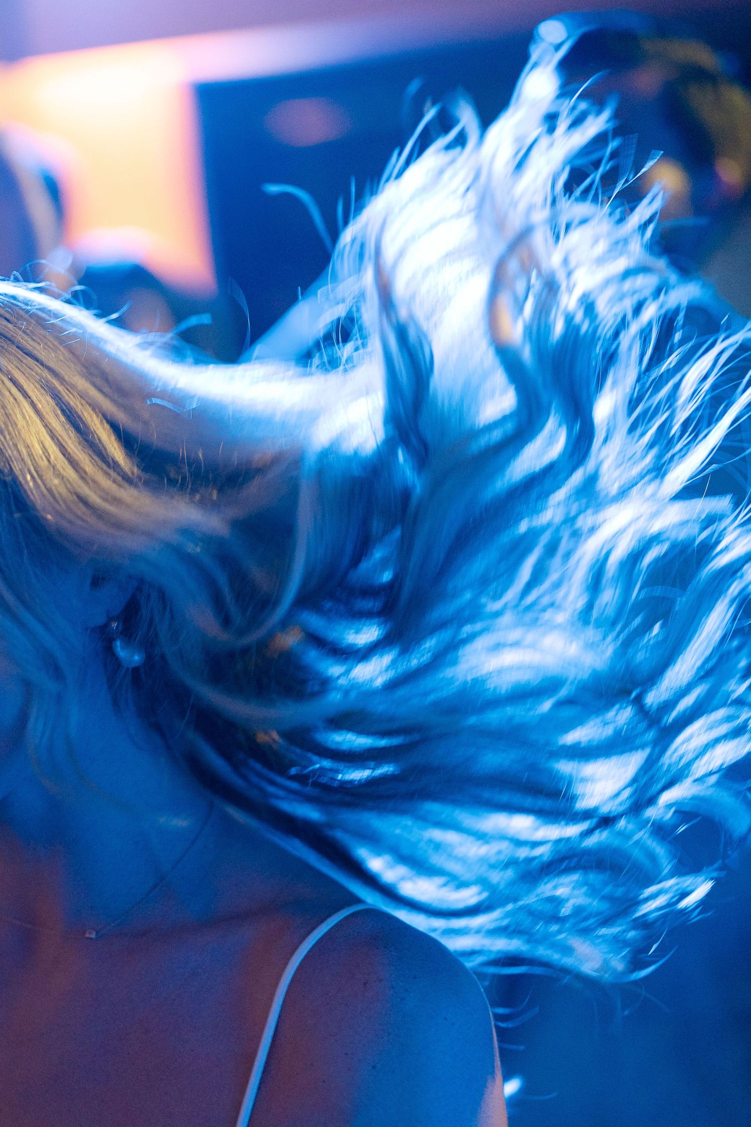 Abstract motion blur photography in blue lighting creates ethereal dance floor effect.