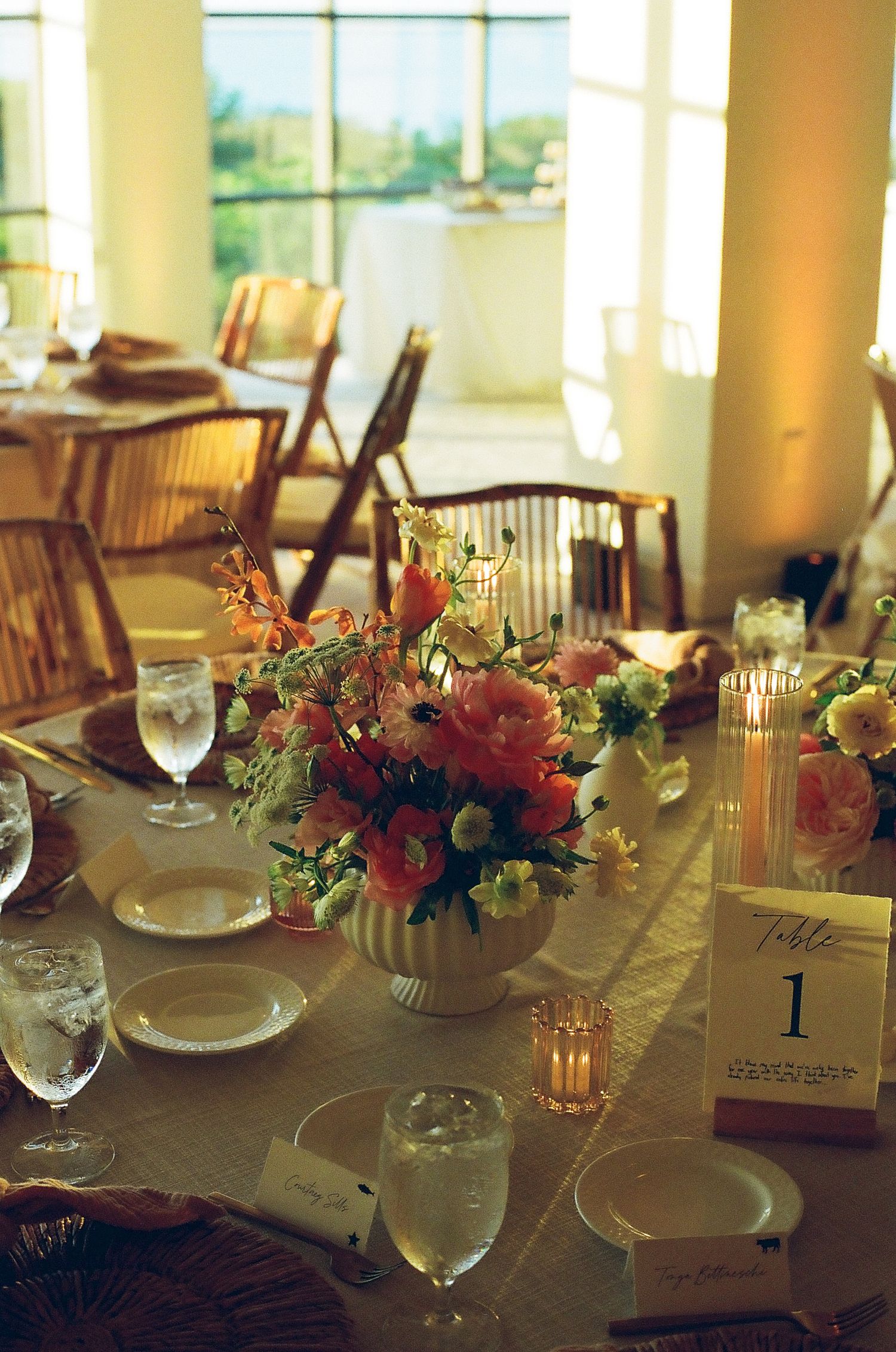 Elegant table settings with floral centerpieces and glassware at a formal dining event.