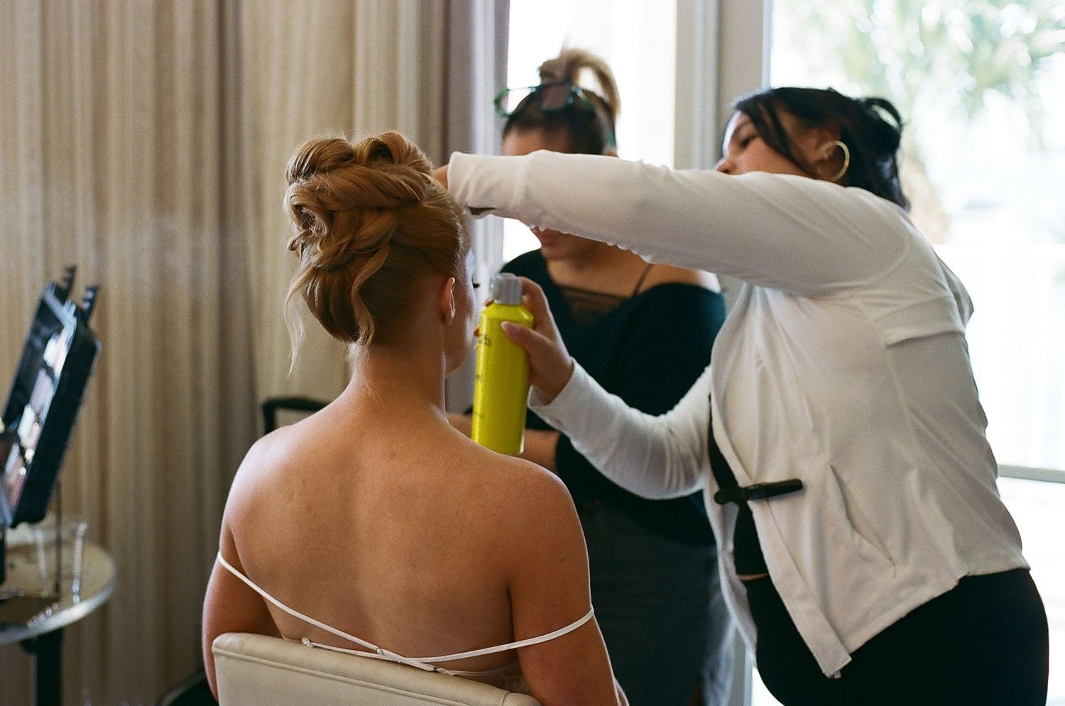 Wedding guests dance and celebrate together at a lively reception with white decor and natural lighting.