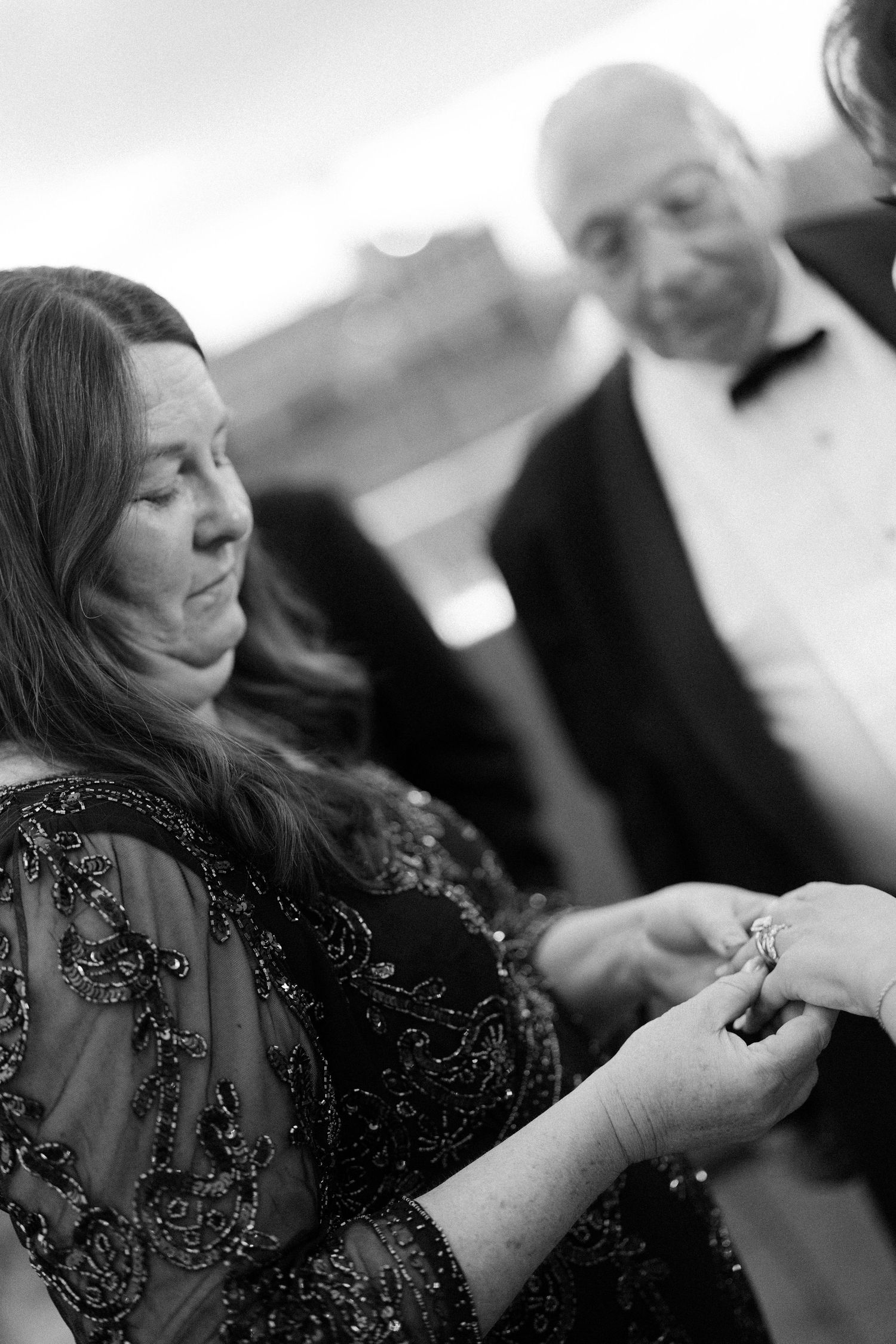 Wedding guest in sparkly black formal attire during an elegant evening reception.