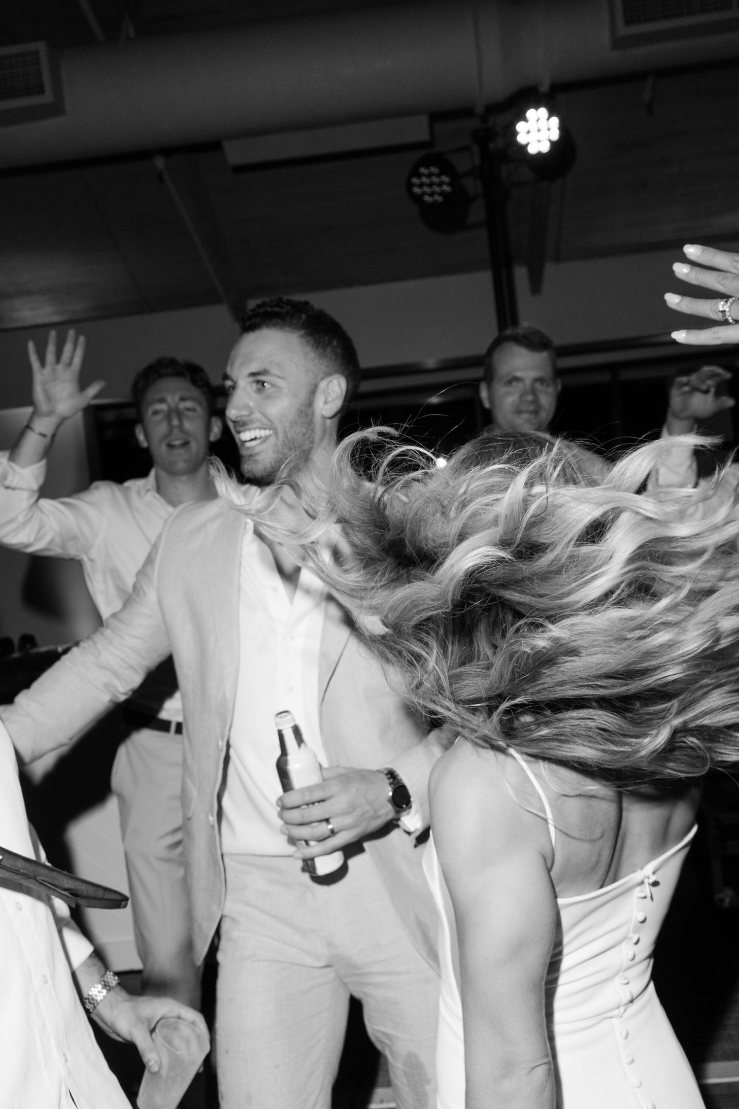 Wedding party dancing and celebrating in black and white photography.