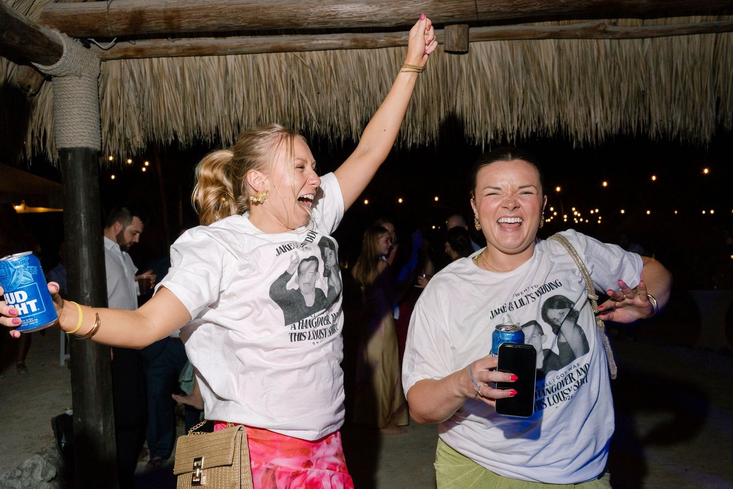 Two people dancing and celebrating at an outdoor party with string lights.