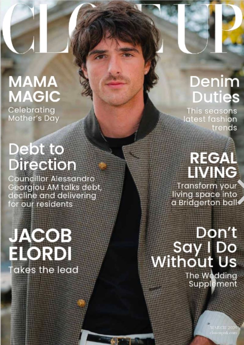 A magazine cover featuring a person in a dark coat against a light background with various article headlines and text.