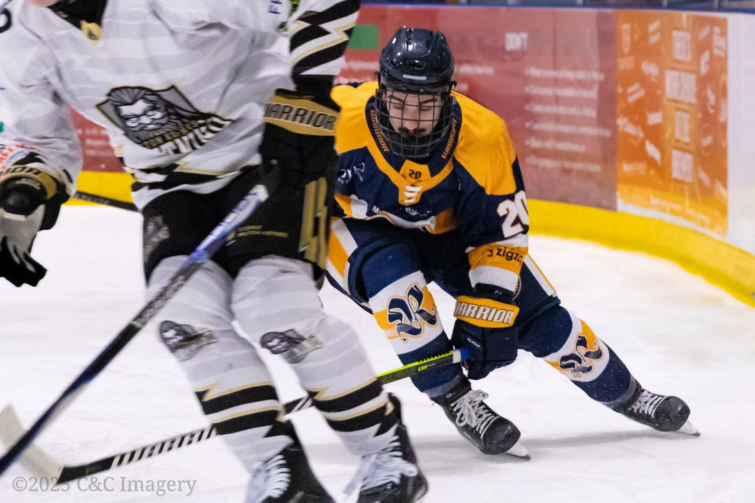 Hockey players in white and navy uniforms battle for the puck during an intense game on the ice.