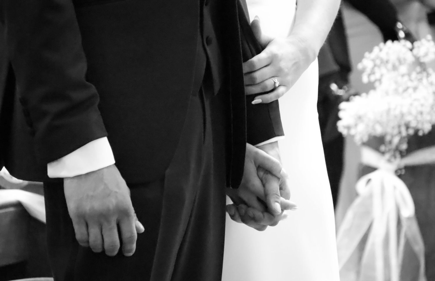 Close-up details of hands during wedding ceremony moments.